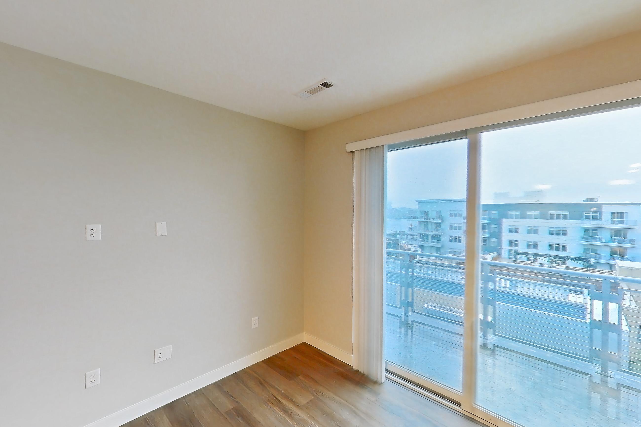 Living room with city view and light wood-finish flooring, Apartment PE2-3508 at Beacon Collection