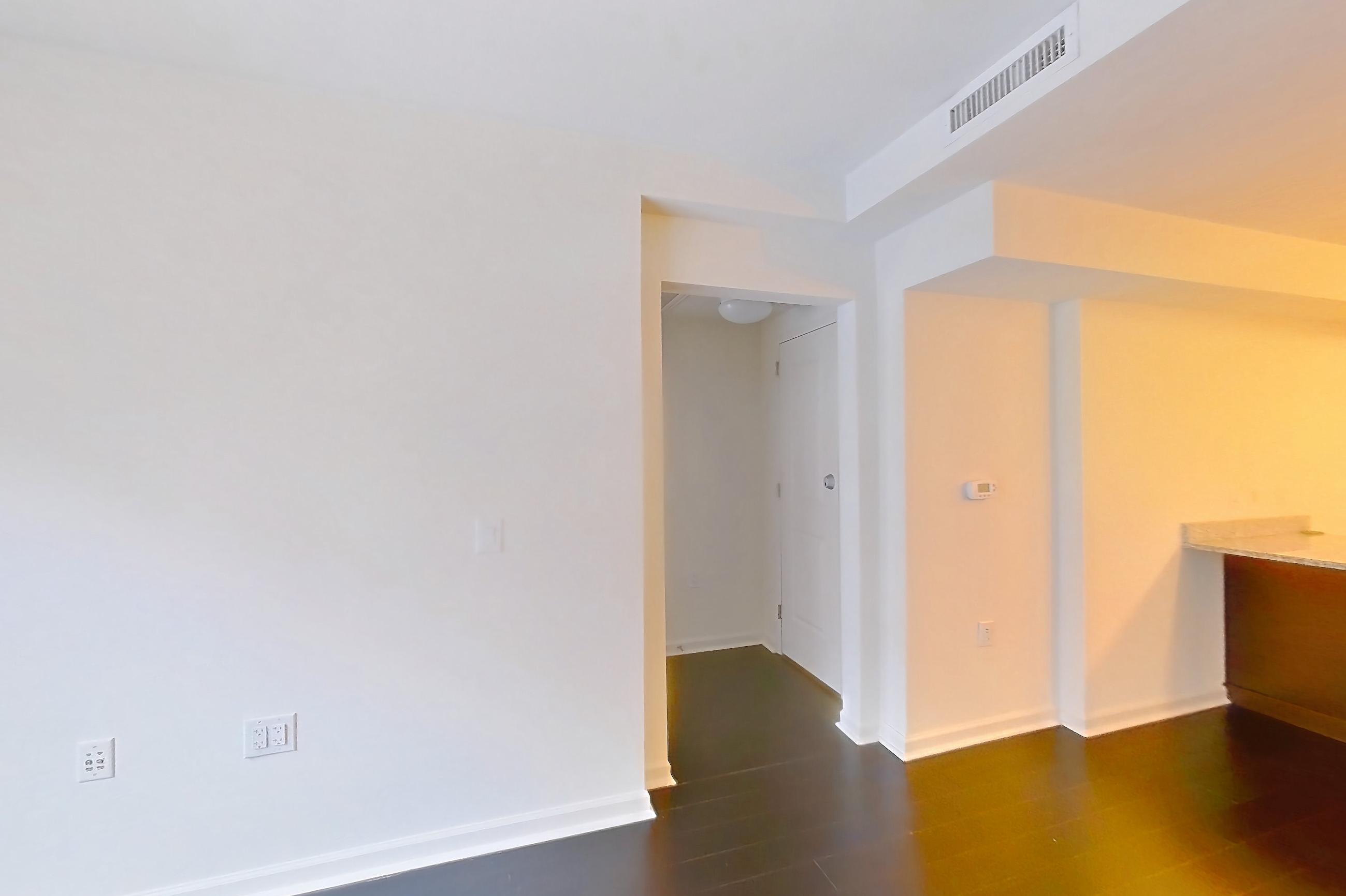 Living room with dark wood-finish flooring, light stone countertops, and wood-finish flooring, Apartment RT-0611 at RiverTrace at Port Imperial