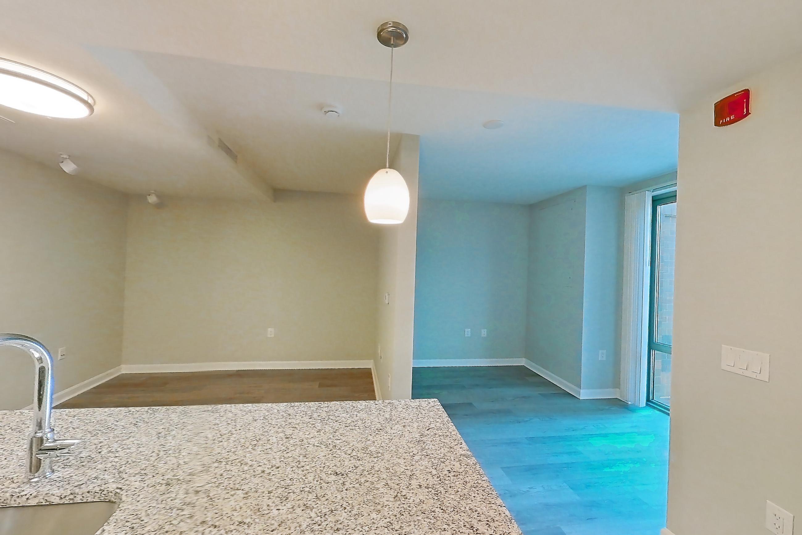 Kitchen with dishwasher, electric range, light countertops, light stone countertops, light tile flooring, light wood-finish flooring, microwave, oven/range, refrigerator, stainless steel appliances, and white appliances, Apartment RT-0615 at RiverTrace at Port Imperial