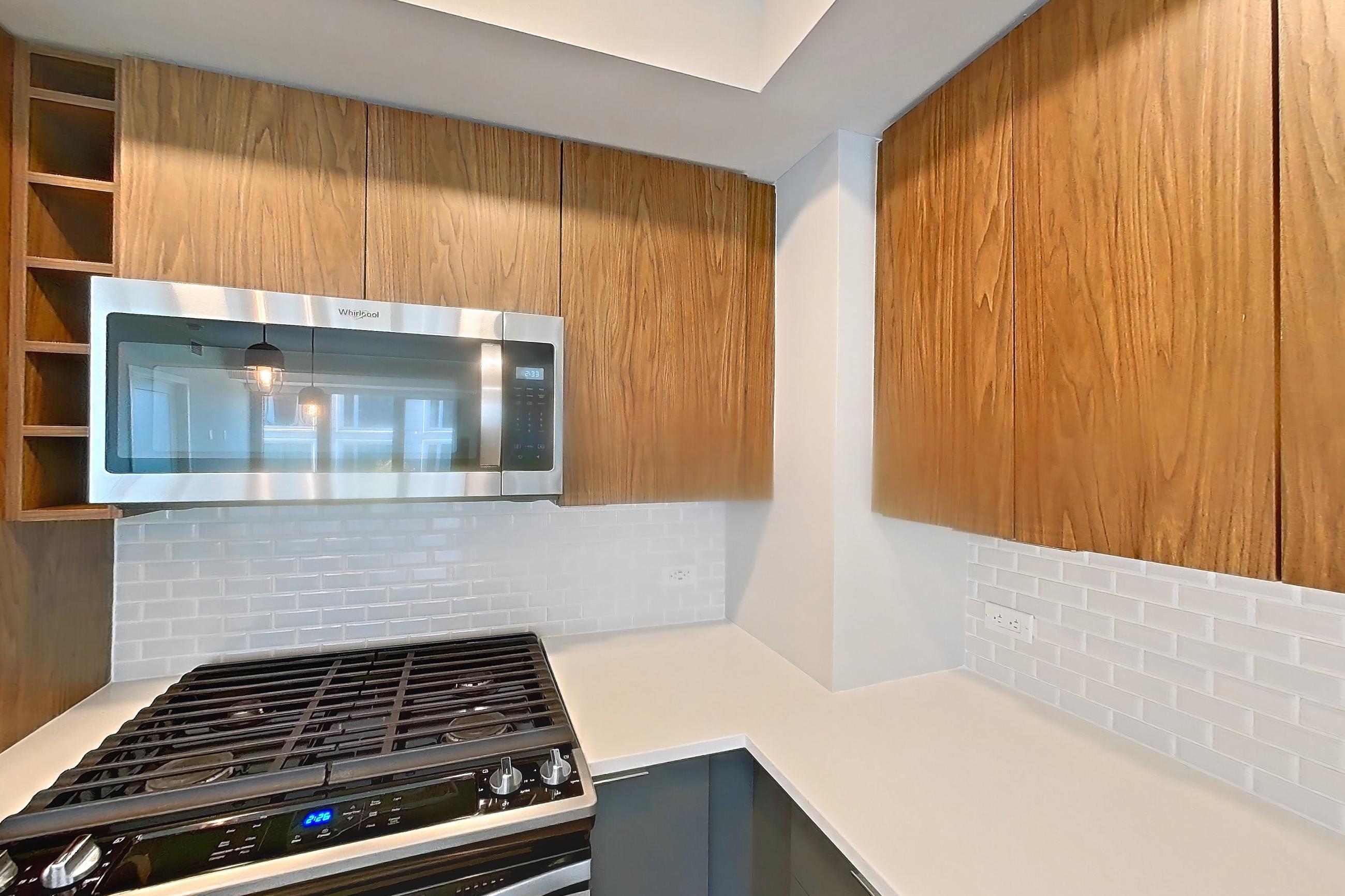 Kitchen with gas range, light countertops, light wood-finish flooring, oven/range, refrigerator, and stainless steel appliances, Apartment RH9-0349 at RiverHouse9