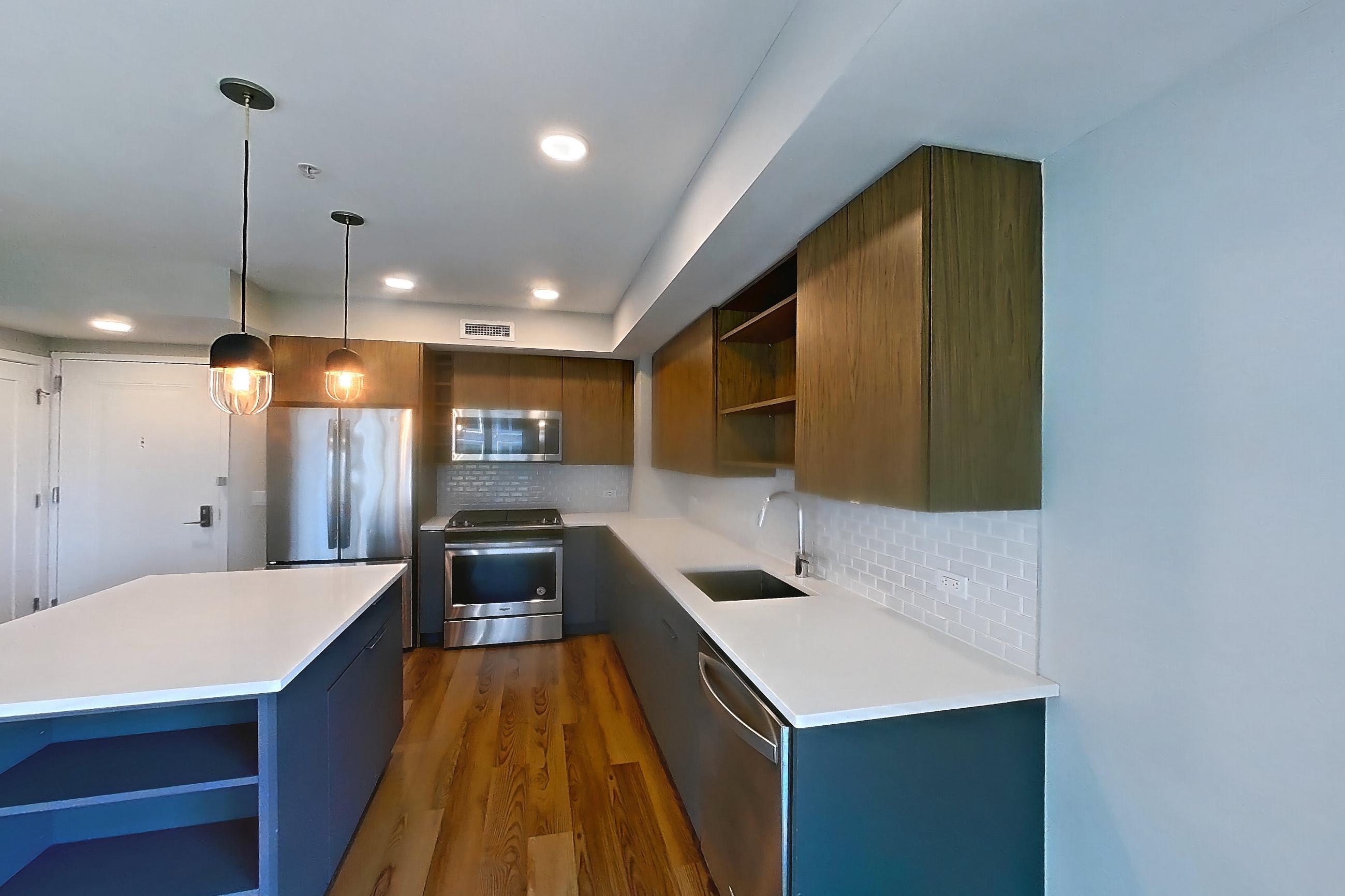 Living space with dark wood-finish flooring, dishwasher, light stone countertops, oven/range, refrigerator, and stainless steel appliances, Apartment RH9-0349 at RiverHouse9