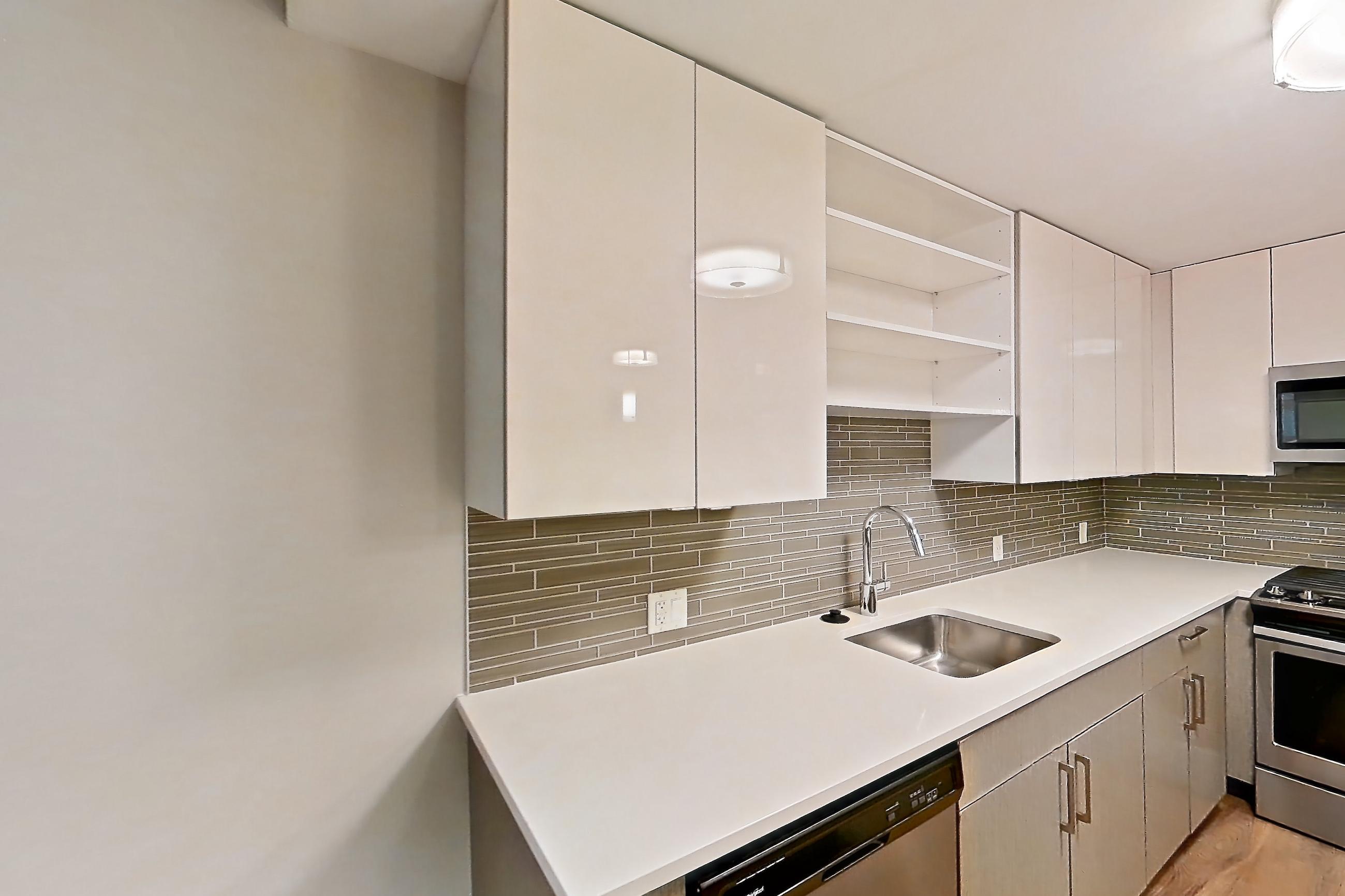 Kitchen with dishwasher, light countertops, light wood-finish flooring, and stainless steel appliances, Apartment RH-0437 at RiverHouse11