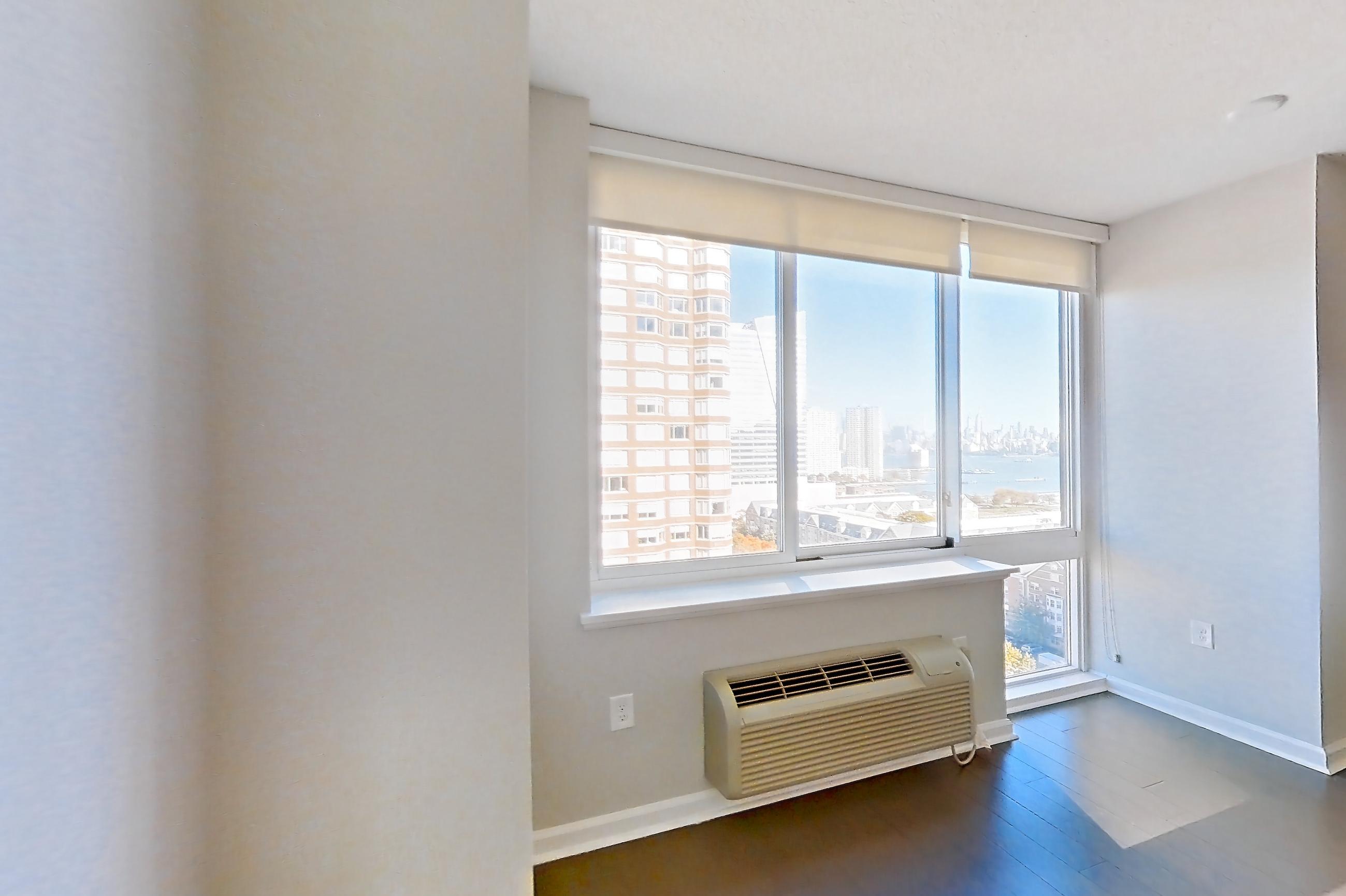 Living space with air conditioning, dark tile flooring, and wood-finish flooring, Apartment M2-1507 at BLVD Collection - 401 Washington Blvd