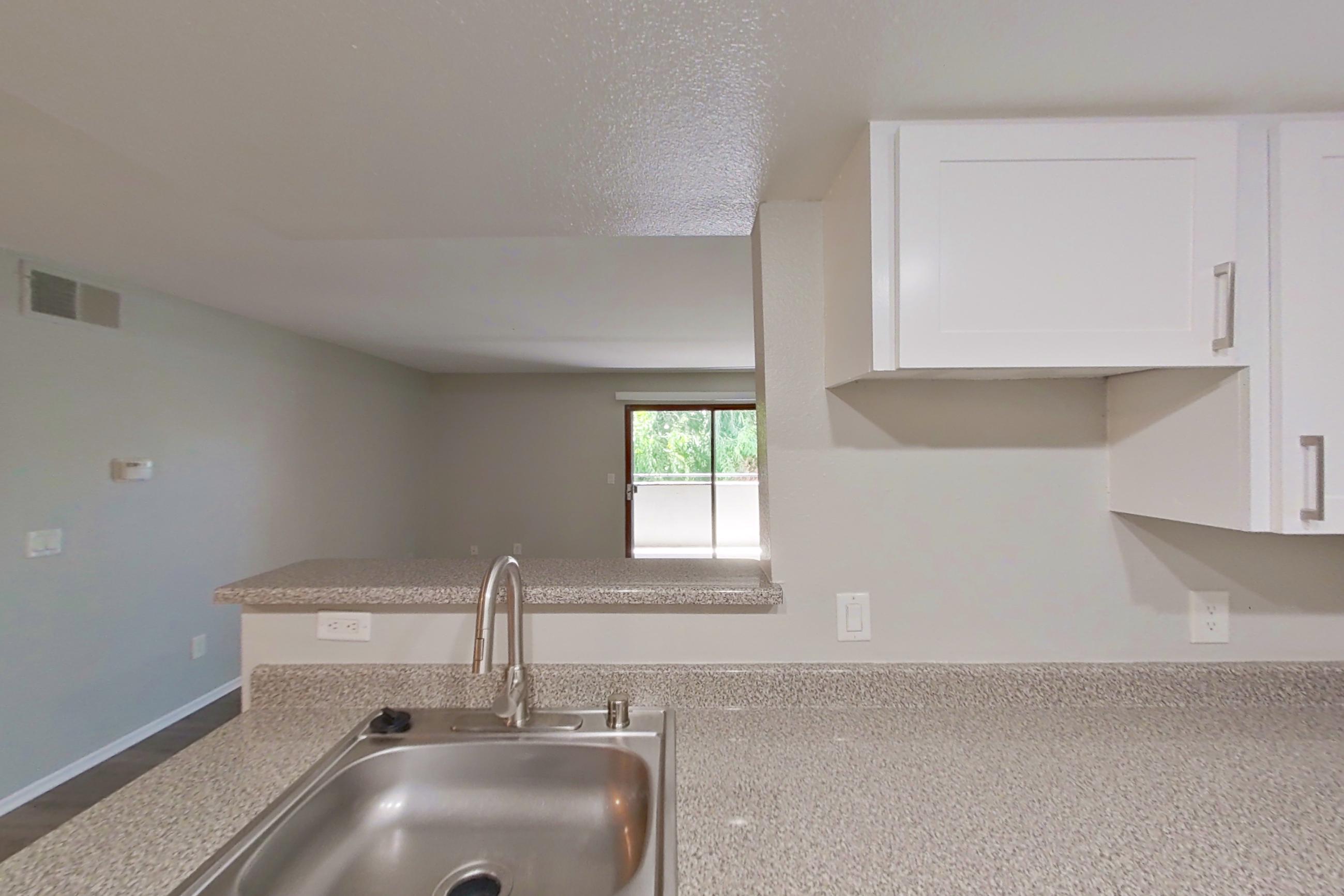 Kitchen with black appliances, dishwasher, electric range, light stone countertops, light wood-finish flooring, oven/range, refrigerator, and stainless steel appliances, Apartment 18 at Avana Rancho Cucamonga