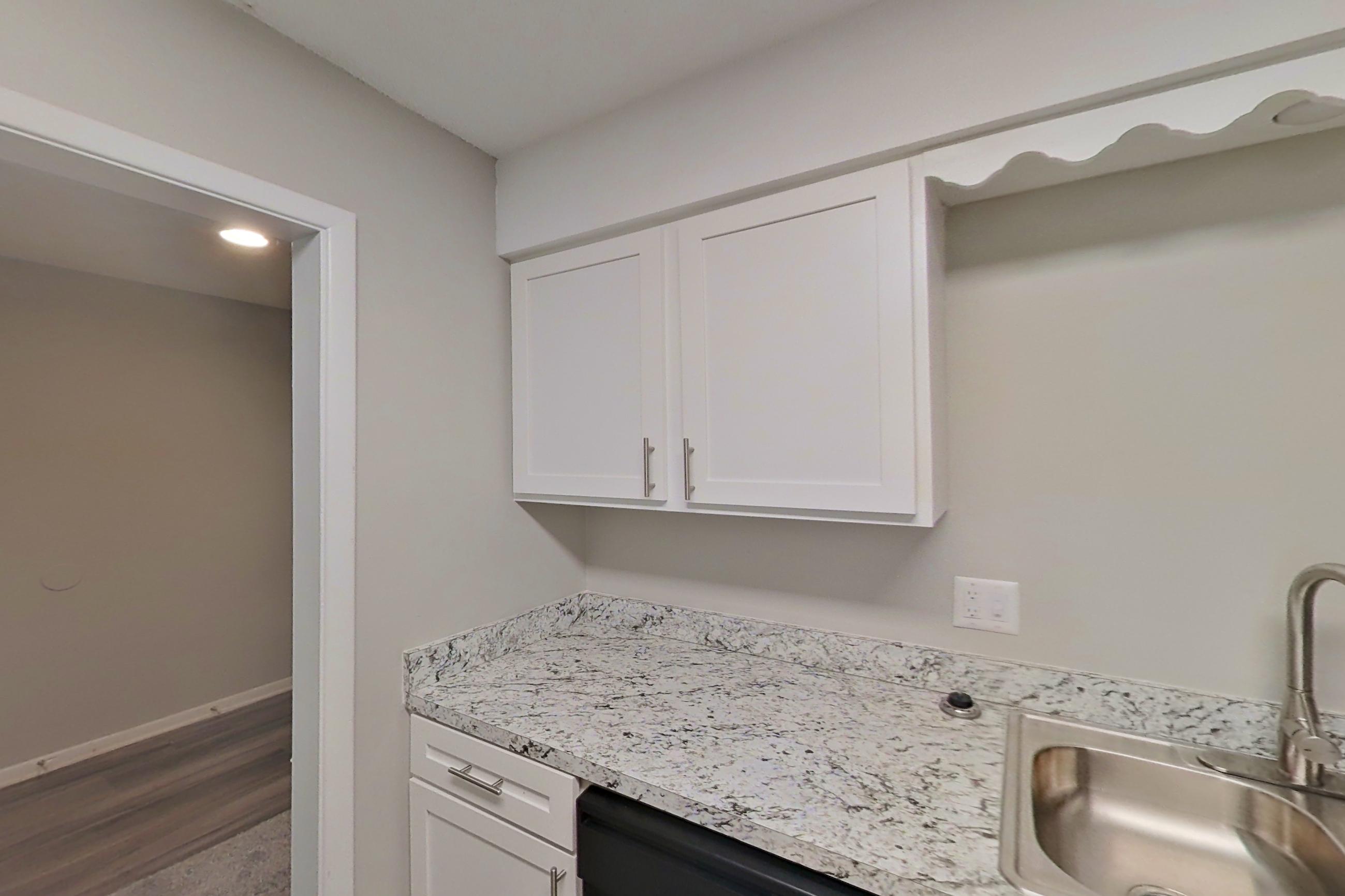 Kitchen with black appliances, dishwasher, light stone countertops, and refrigerator, Apartment 9714A at The Life at Legacy Fountains