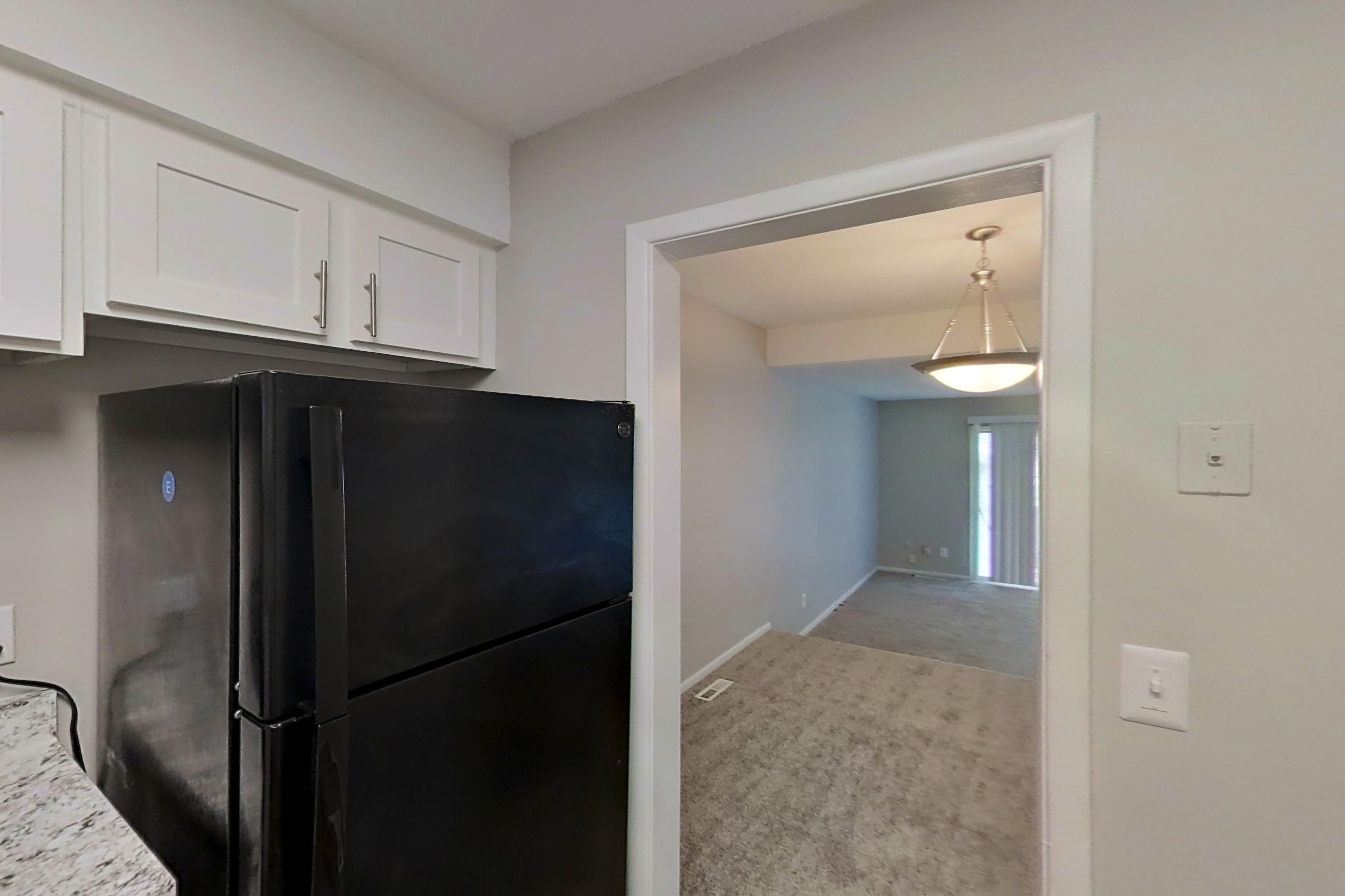 Kitchen with black appliances, dishwasher, light stone countertops, and refrigerator, Apartment 9714A at The Life at Legacy Fountains