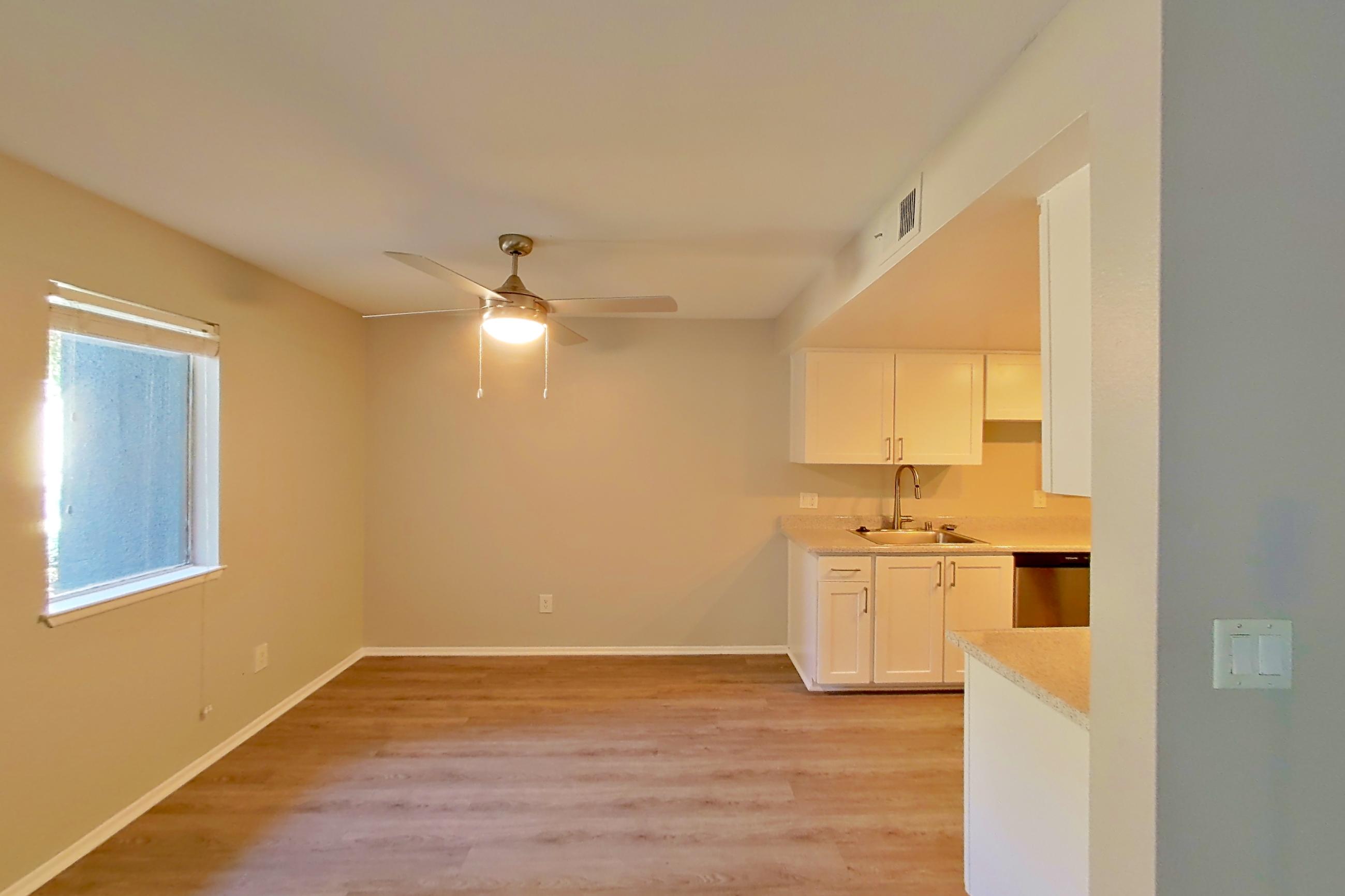 Living space with dark wood-finish flooring, dishwasher, light wood-finish flooring, and stainless steel appliances, Apartment 06 at Avana Rancho Cucamonga