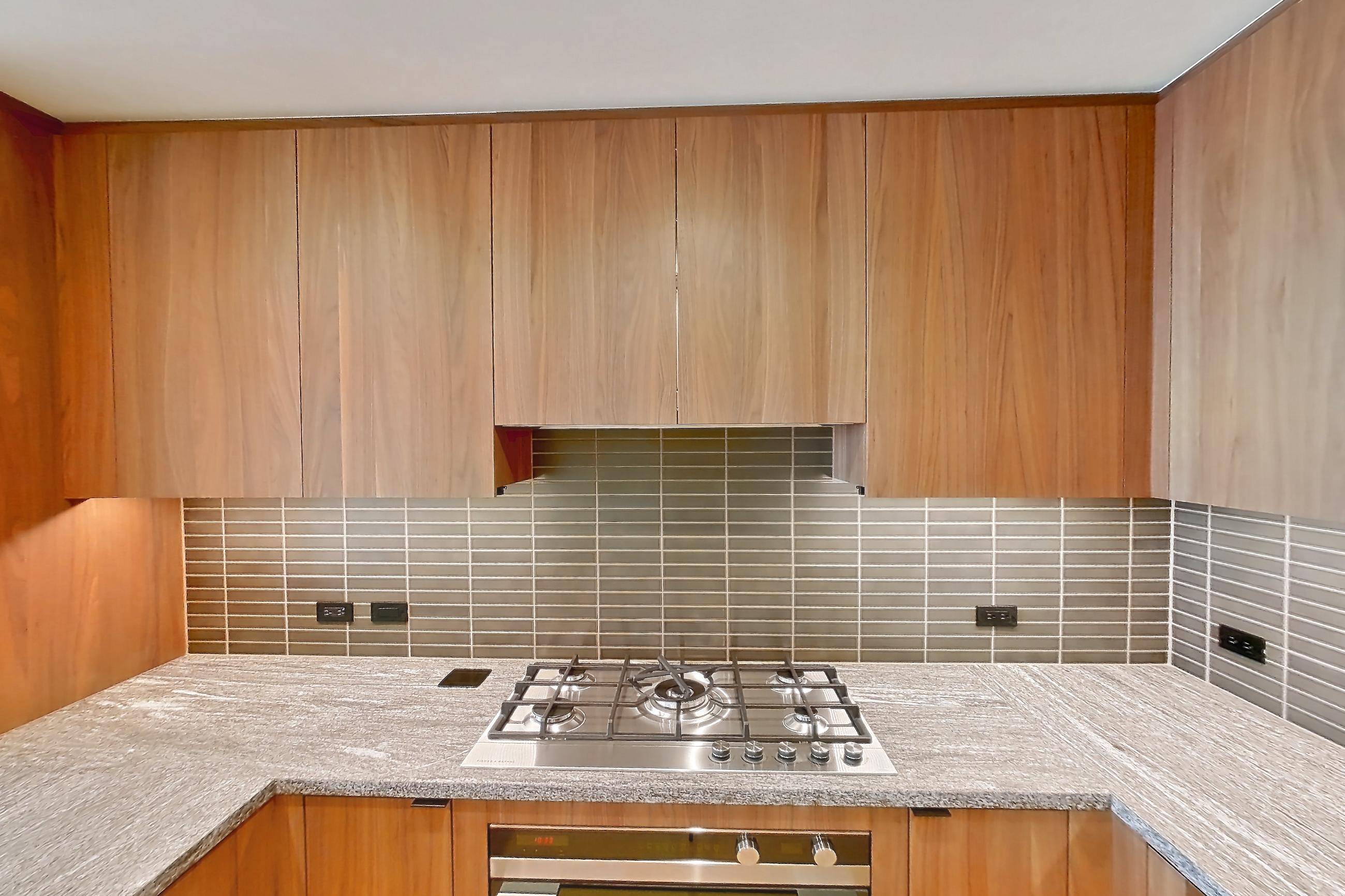 Kitchen with cooktop, gas cooktop, light stone countertops, oven/range, and stainless steel appliances, Apartment B-5002 at Beaudry