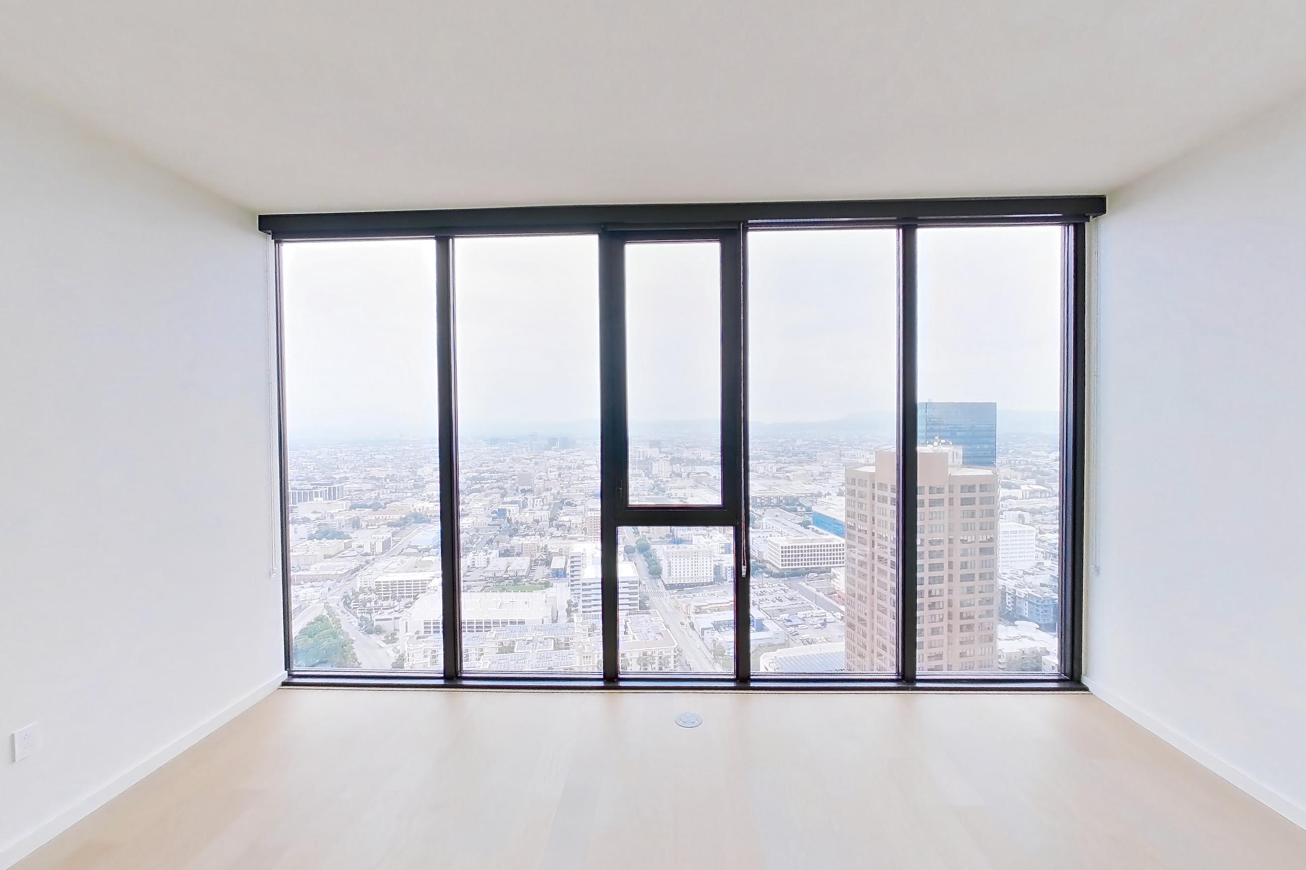 Living room with city view and light wood-finish flooring, Apartment B-5002 at Beaudry