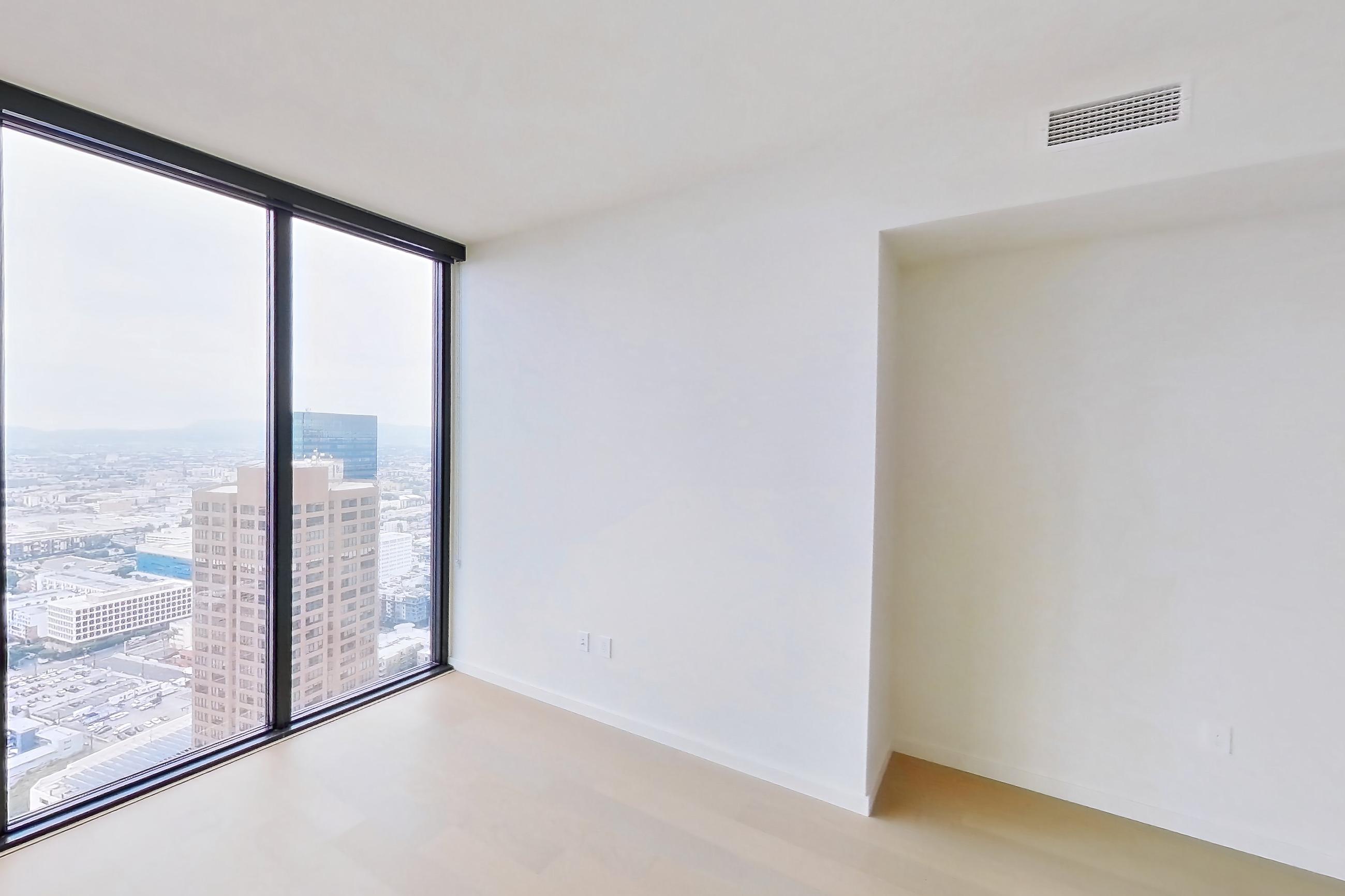 Living room with city view and light wood-finish flooring, Apartment B-5002 at Beaudry