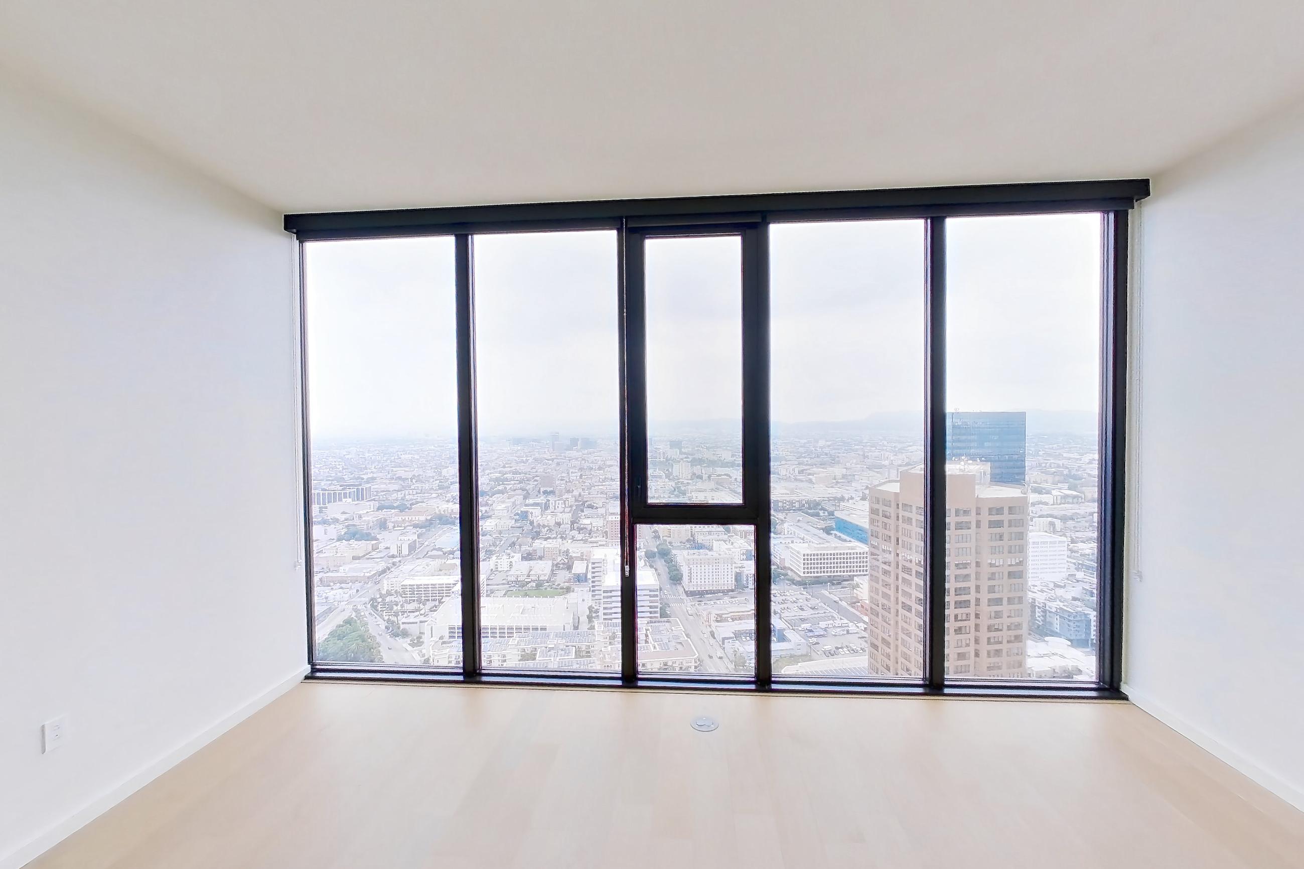 Living room with city view and light wood-finish flooring, Apartment B-5202 at Beaudry