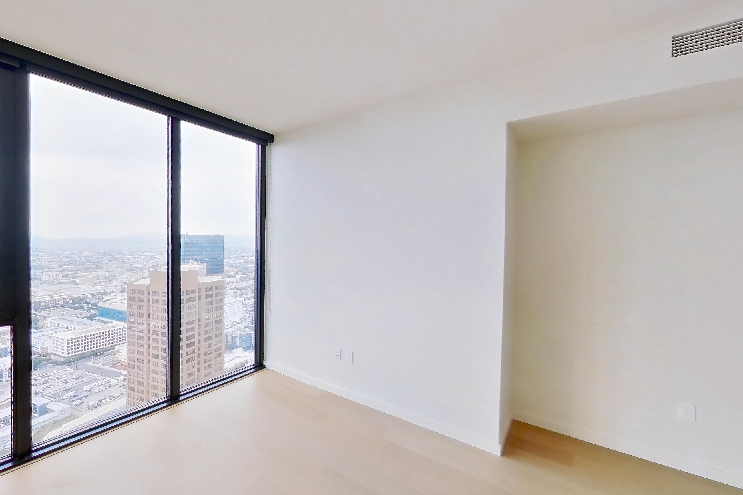 Living room with city view and light wood-finish flooring, Apartment B-5202 at Beaudry