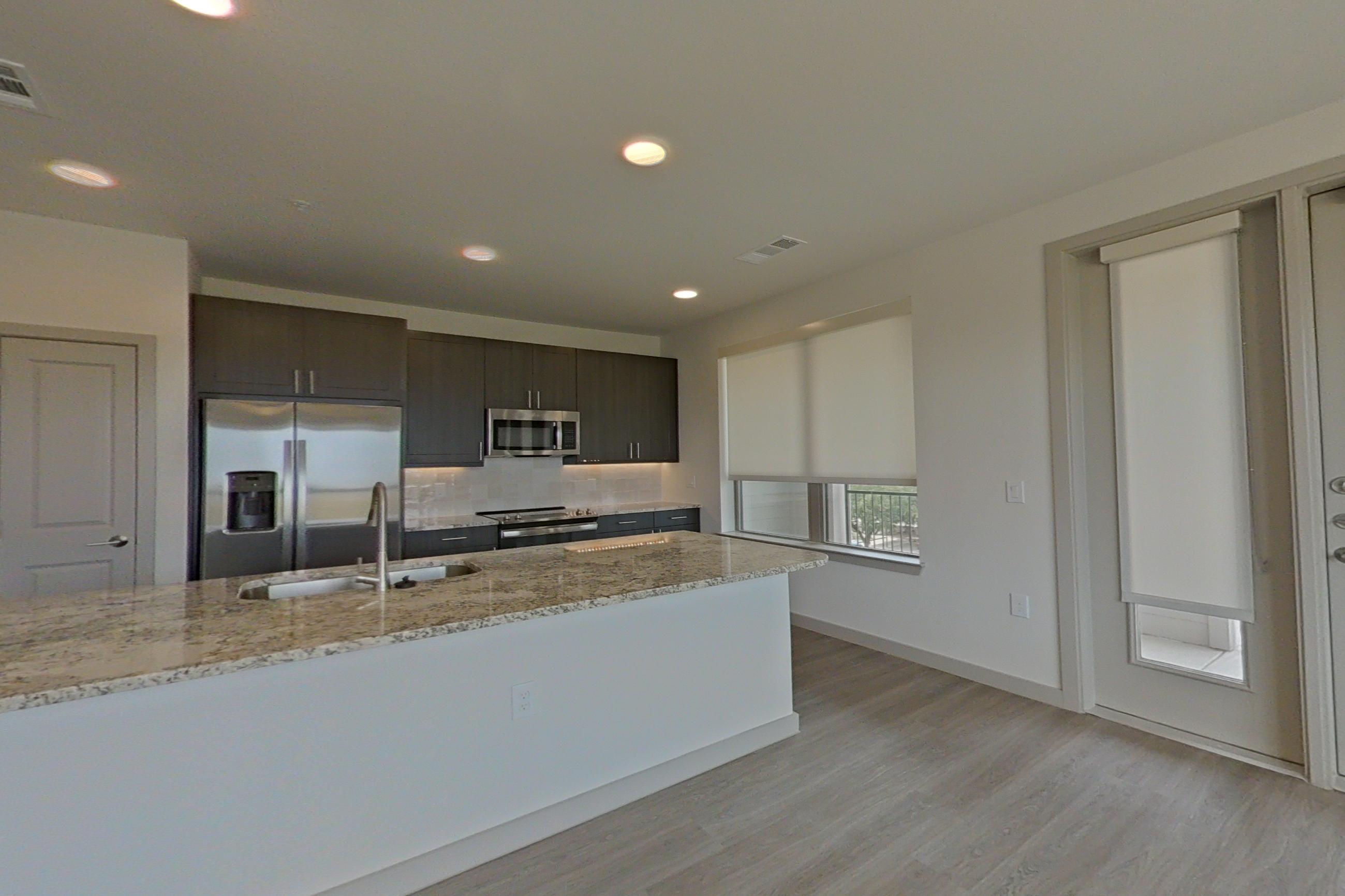 Living room with kitchen island, light stone countertops, and light wood-finish flooring, Apartment 1305 at Merit Lewisville