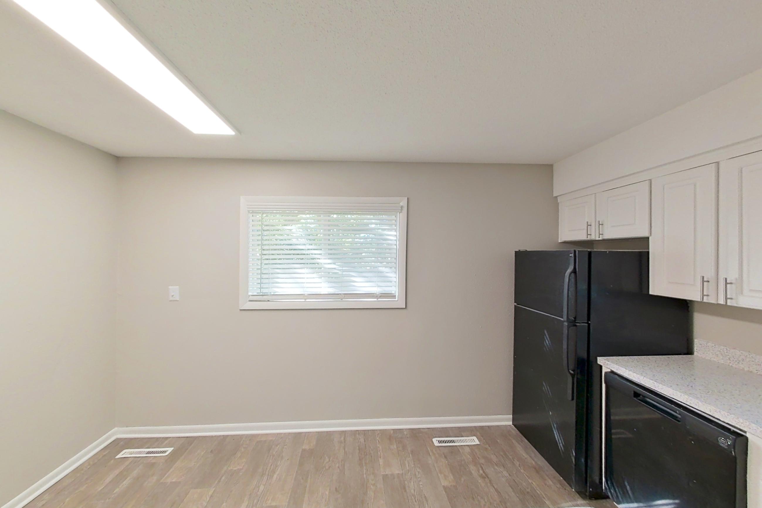 Kitchen with black appliances, dishwasher, electric range, light stone countertops, light wood-finish flooring, oven/range, and refrigerator, Apartment 1707 at The Life at Legacy Fountains