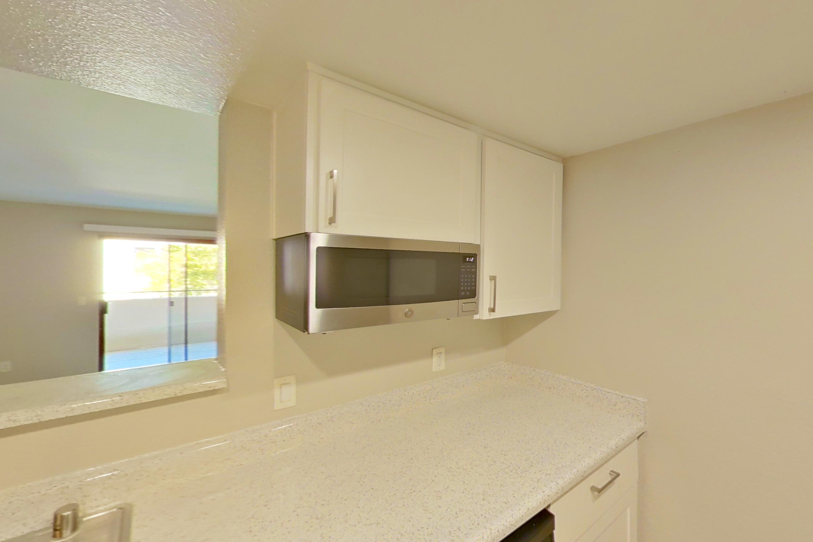 Kitchen with dishwasher, electric range, light stone countertops, light wood-finish flooring, oven/range, refrigerator, stainless steel appliances, and white appliances, Apartment 19 at Avana Rancho Cucamonga