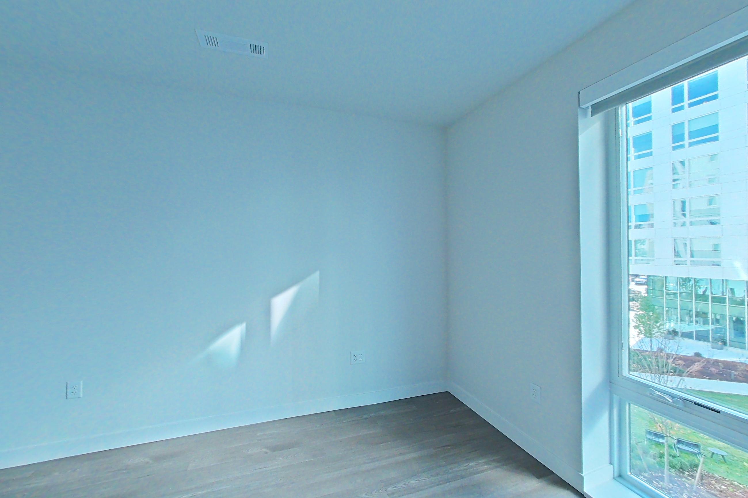 Living space with dark wood-finish flooring, oven/range, and stainless steel appliances, Apartment C306 at The Laurent
