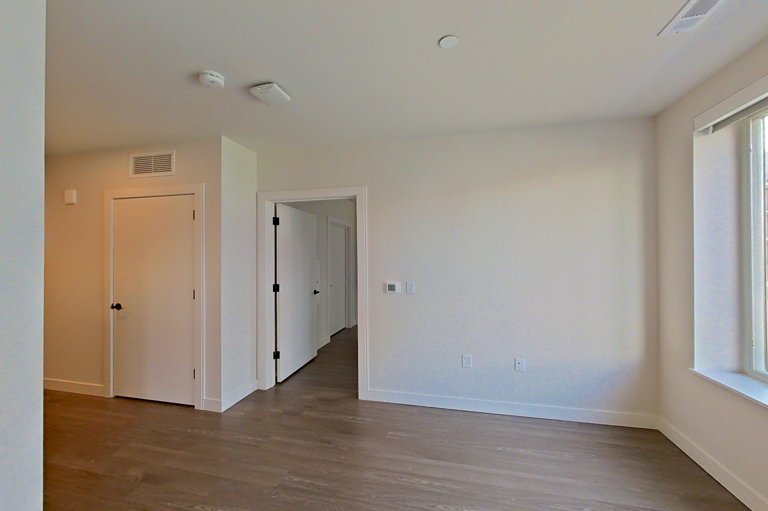 Living room with dark wood-finish flooring, Apartment C217 at The Laurent