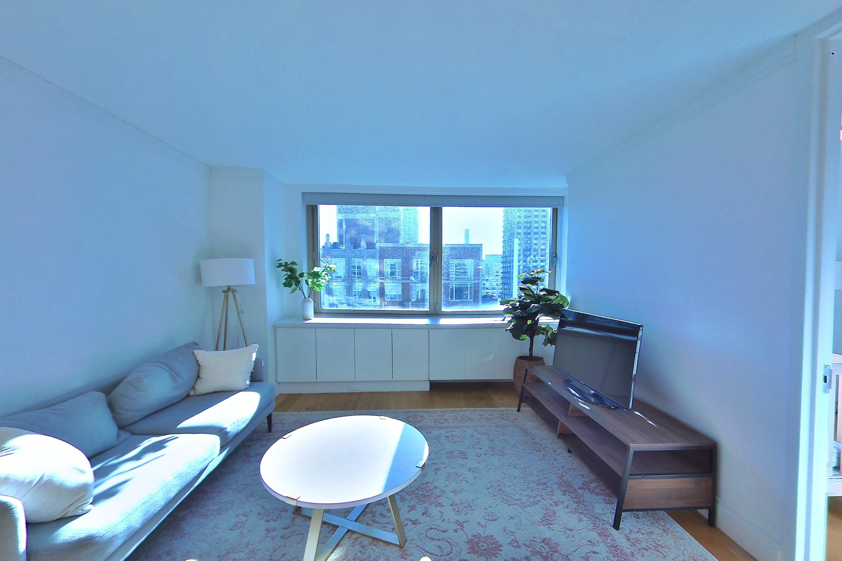 Living space with city view and light wood-finish flooring, Apartment 21C at The Colorado