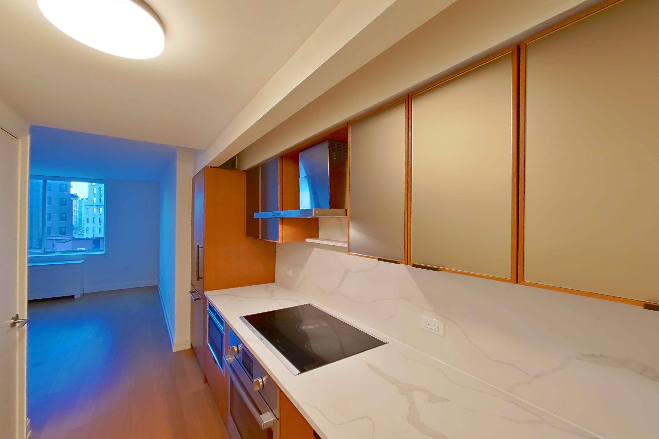 Kitchen with black appliances, cooktop, electric cooktop, light stone countertops, light wood-finish flooring, oven/range, and stainless steel appliances, Apartment 1414 at Oriana
