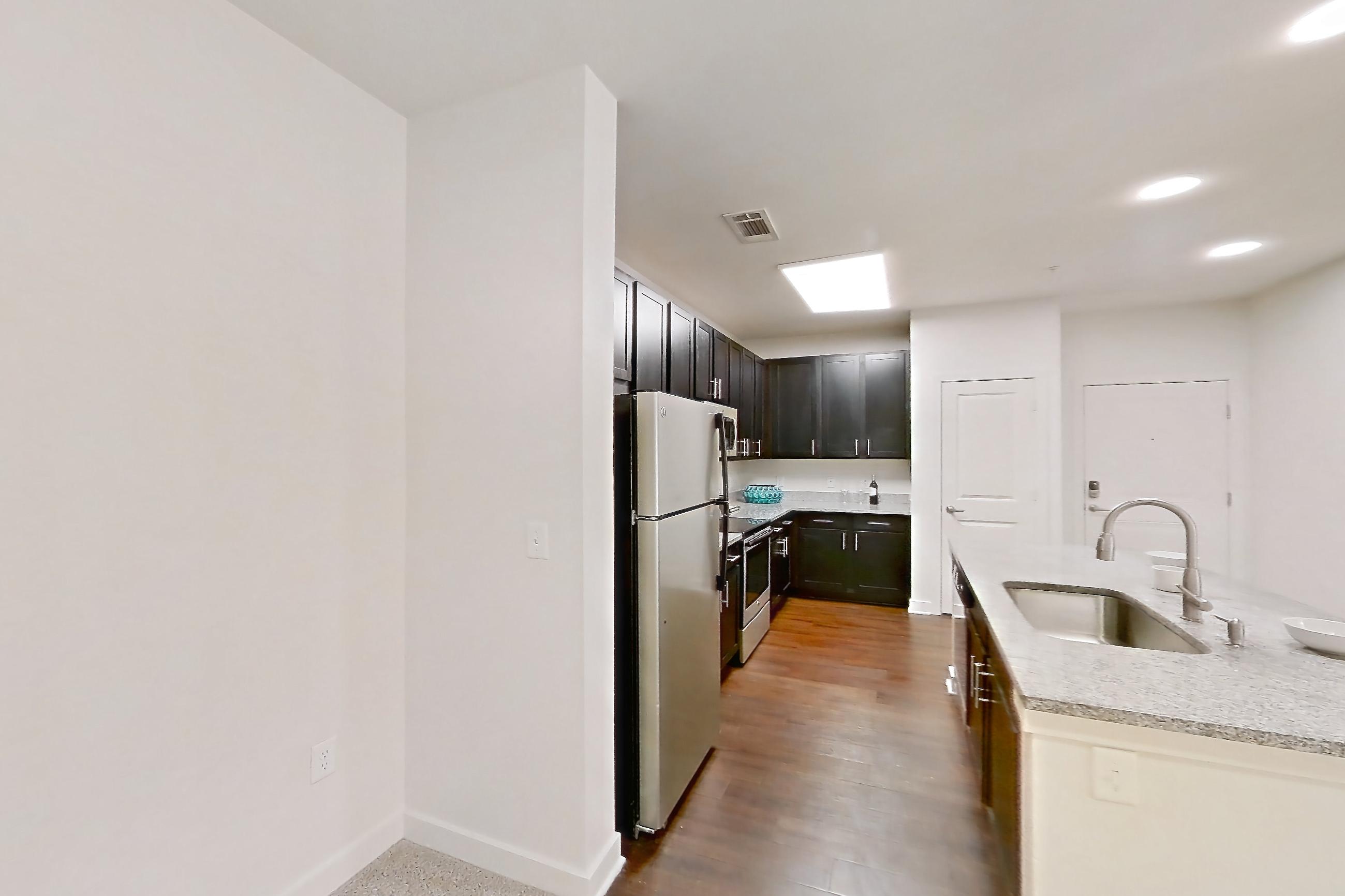 Dining room with dark carpet, electric range, kitchen island, light countertops, light stone countertops, oven/range, refrigerator, stainless steel appliances, and white appliances, Apartment 208 at Realm at Patterson Place