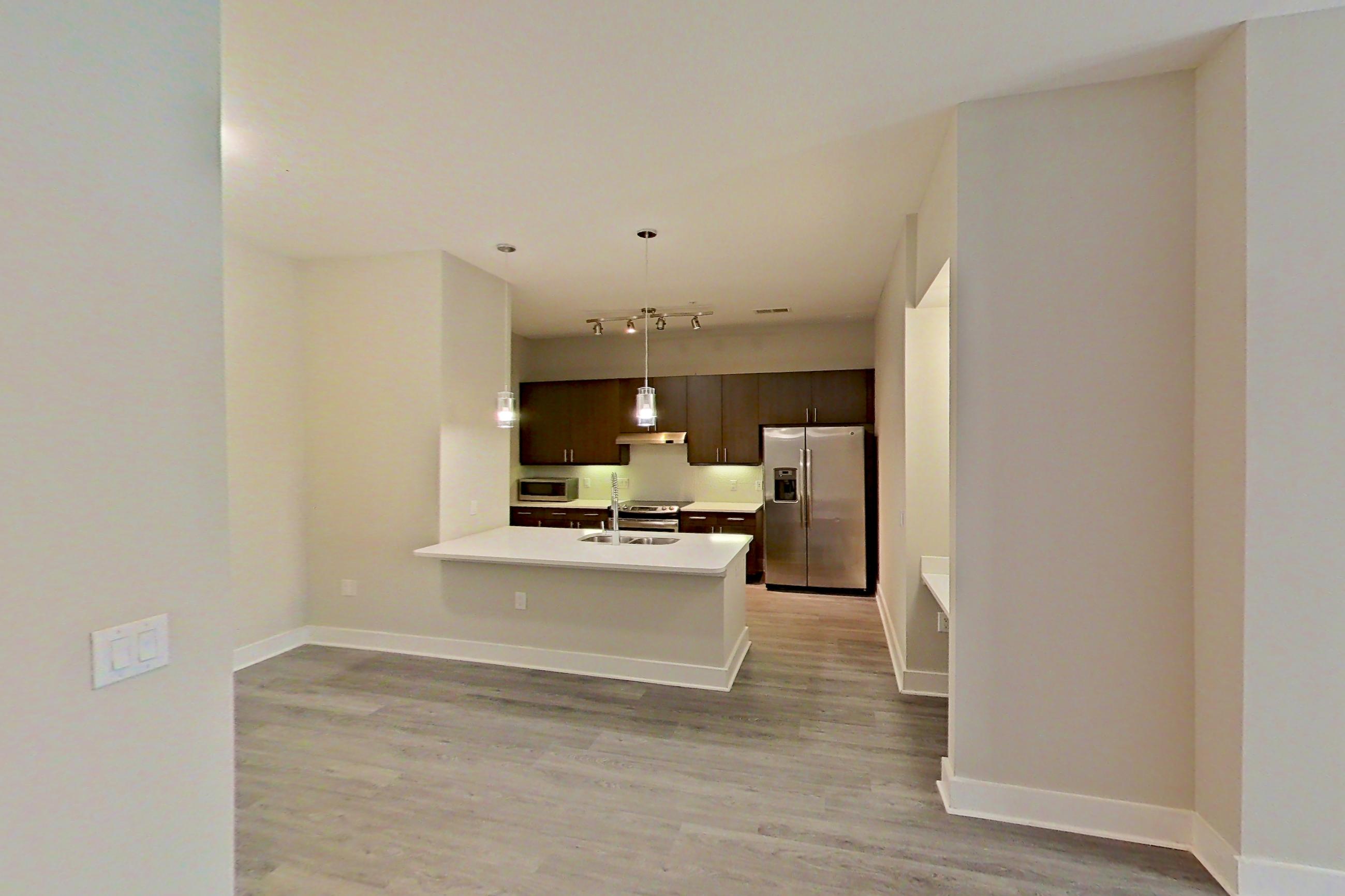 Dining room with electric range, light countertops, light wood-finish flooring, microwave, oven/range, refrigerator, stainless steel appliances, and water & ice dispenser, Apartment 331 at BullHouse