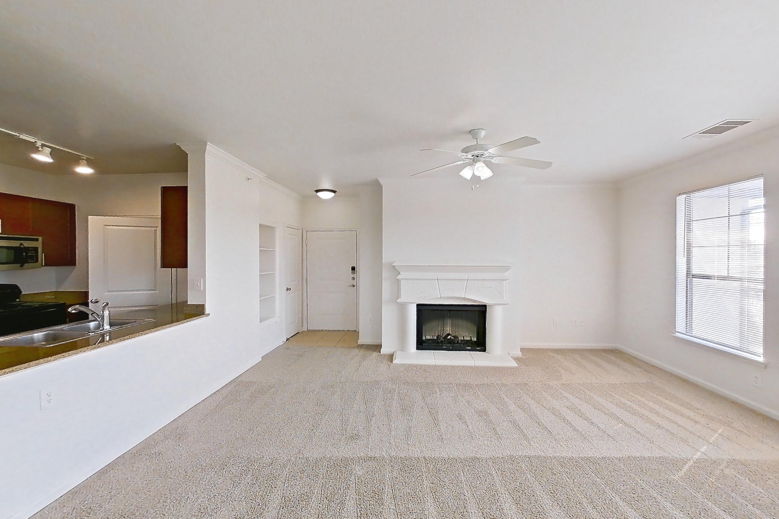 Dining room with black appliances, electric range, fireplace, light carpet, oven/range, refrigerator, and stainless steel appliances, Apartment 731 at The Cortona