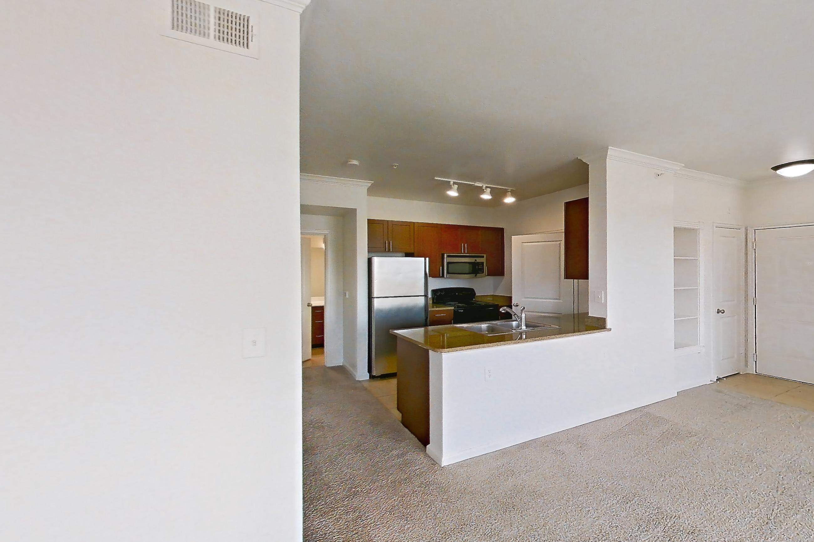 Dining room with black appliances, electric range, fireplace, light carpet, oven/range, refrigerator, and stainless steel appliances, Apartment 731 at The Cortona