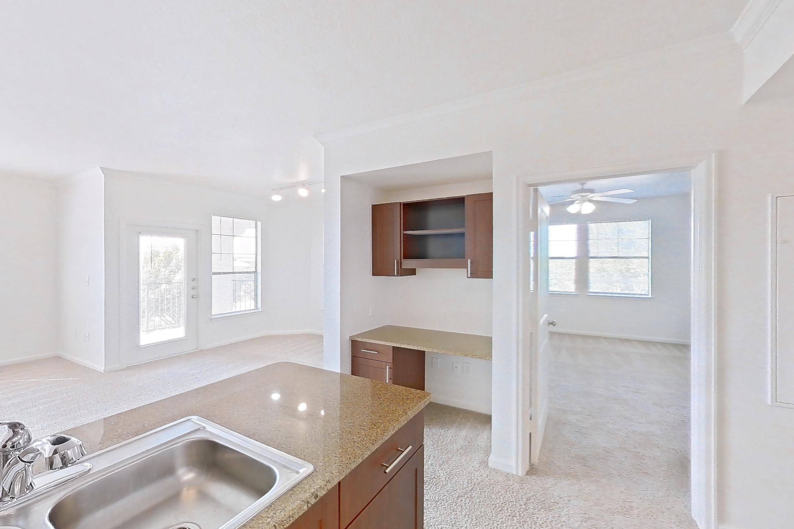 Kitchen with black appliances, dishwasher, electric range, light carpet, light stone countertops, light tile flooring, oven/range, refrigerator, and stainless steel appliances, Apartment 731 at The Cortona