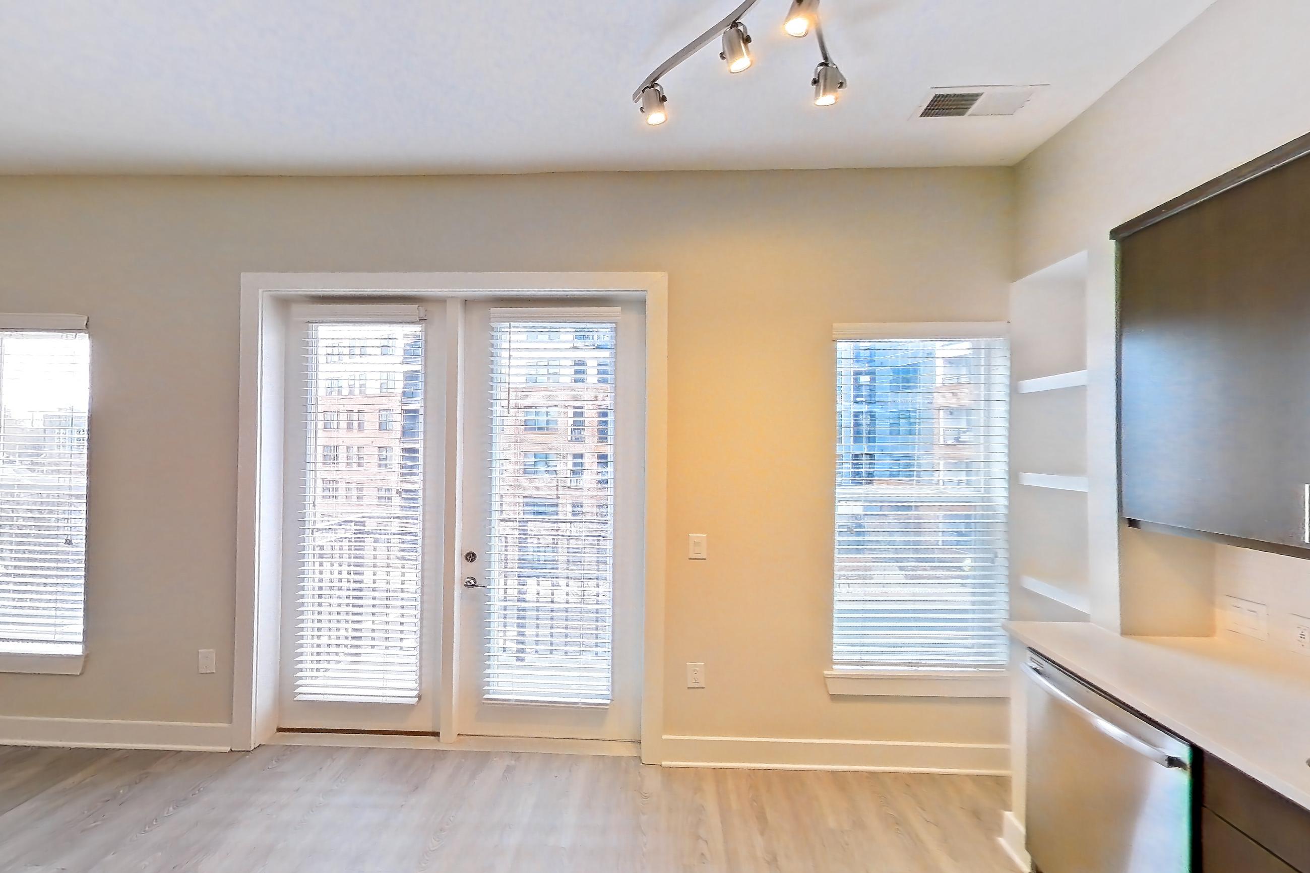 Kitchen with dishwasher, electric range, light countertops, light wood-finish flooring, microwave, oven/range, refrigerator, stainless steel appliances, and water & ice dispenser, Apartment 415 at BullHouse