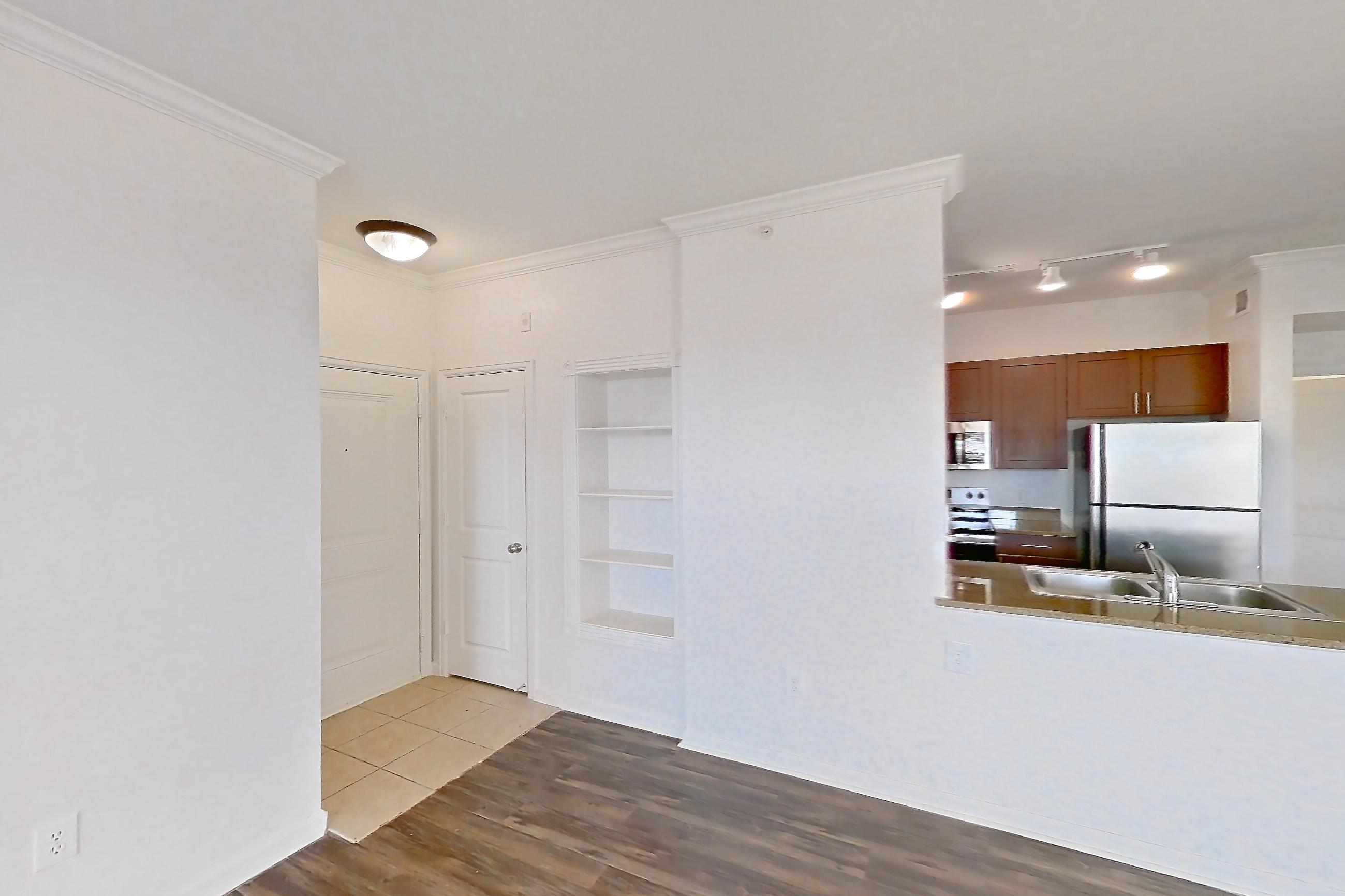 Living room with dark wood-finish flooring, microwave, oven/range, refrigerator, stainless steel appliances, and white appliances, Apartment 811 at The Cortona