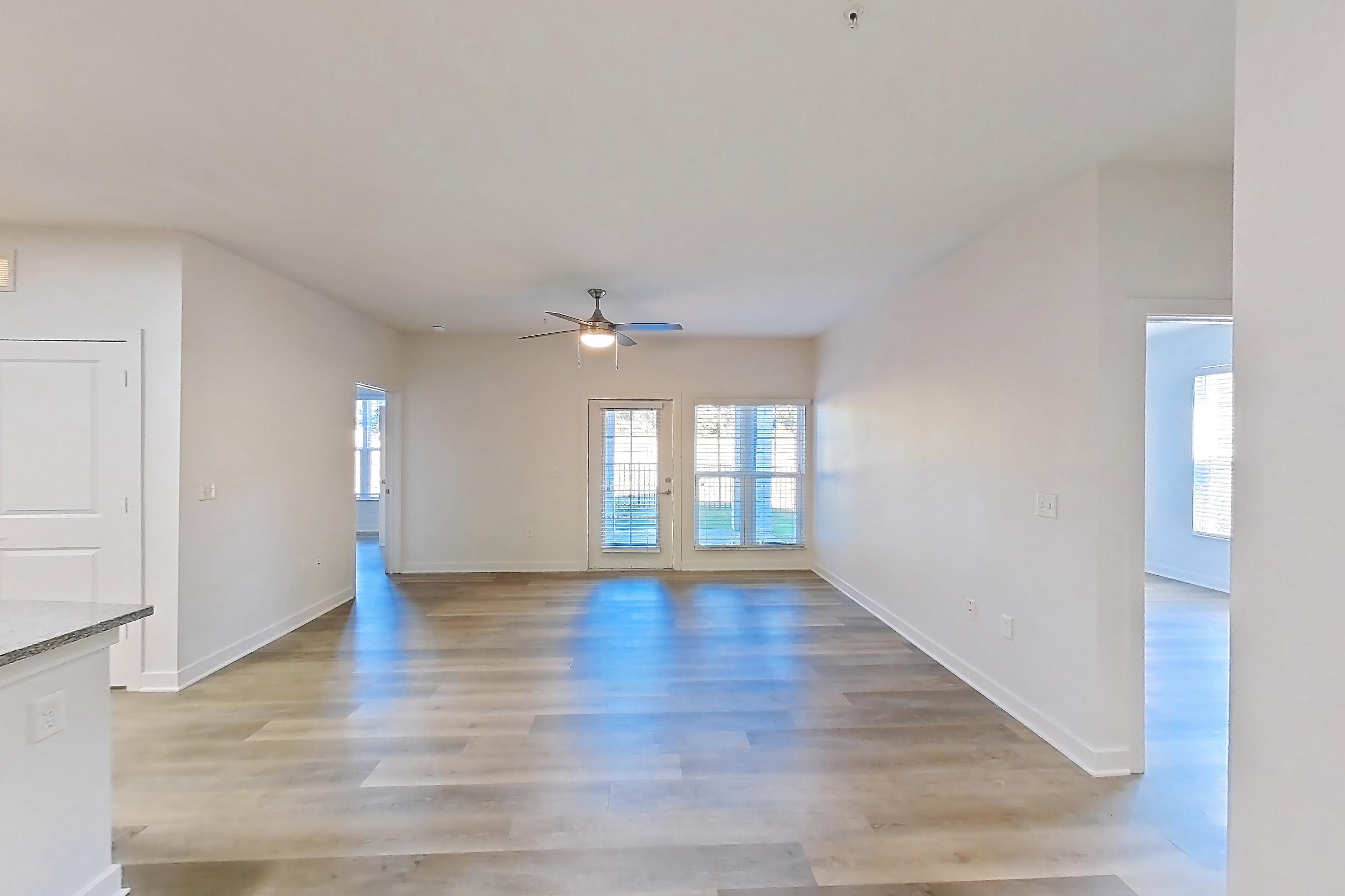 Dining room with kitchen island, light stone countertops, light wood-finish flooring, refrigerator, and white appliances, Apartment 008 at Realm at Patterson Place