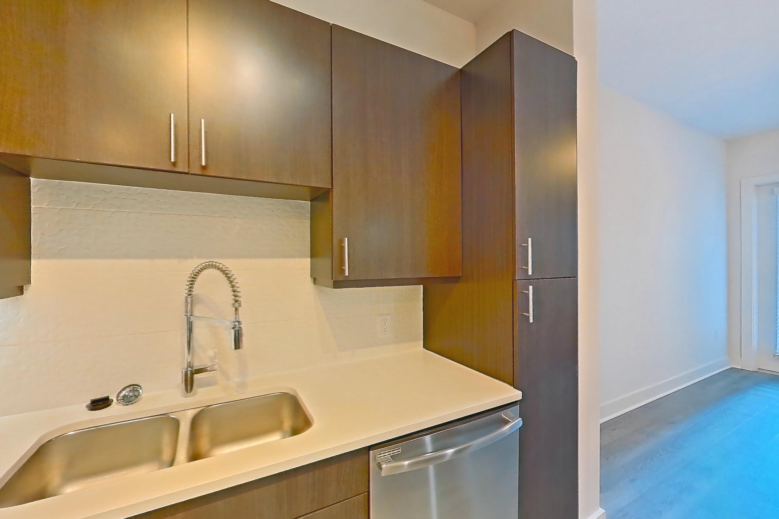 Kitchen with dishwasher, electric range, light countertops, light wood-finish flooring, microwave, oven/range, refrigerator, stainless steel appliances, and water & ice dispenser, Apartment 562 at BullHouse