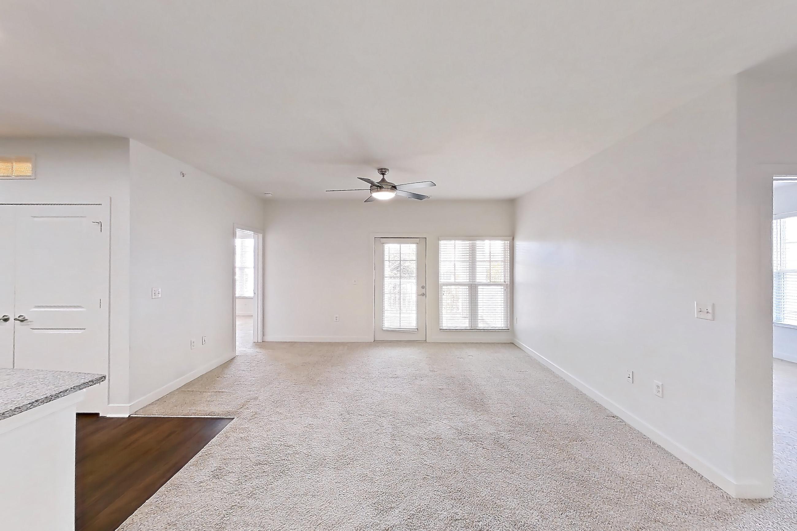 Dining room with dark carpet, kitchen island, light stone countertops, refrigerator, and white appliances, Apartment 208 at Realm at Patterson Place