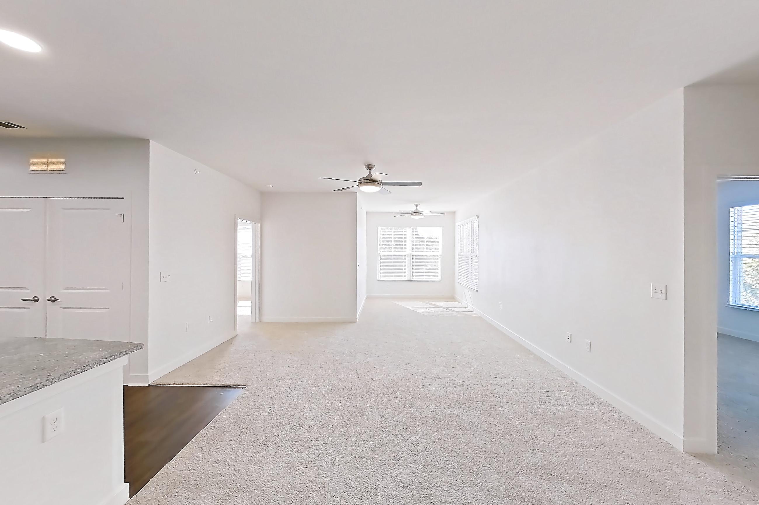 Dining room with dark carpet, dishwasher, kitchen island, light stone countertops, refrigerator, and stainless steel appliances, Apartment 301 at Realm at Patterson Place