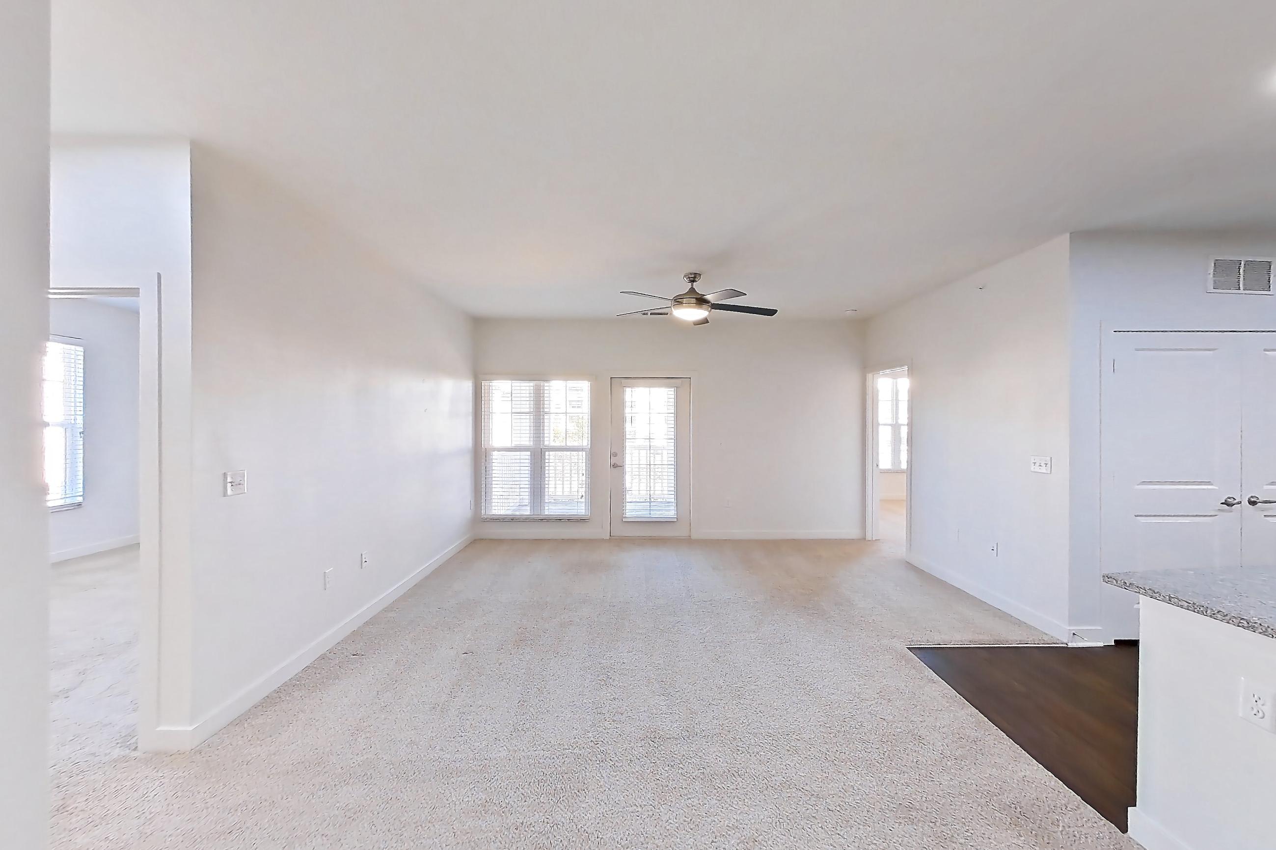 Dining room with dark carpet, dishwasher, kitchen island, light stone countertops, refrigerator, stainless steel appliances, and white appliances, Apartment 302 at Realm at Patterson Place