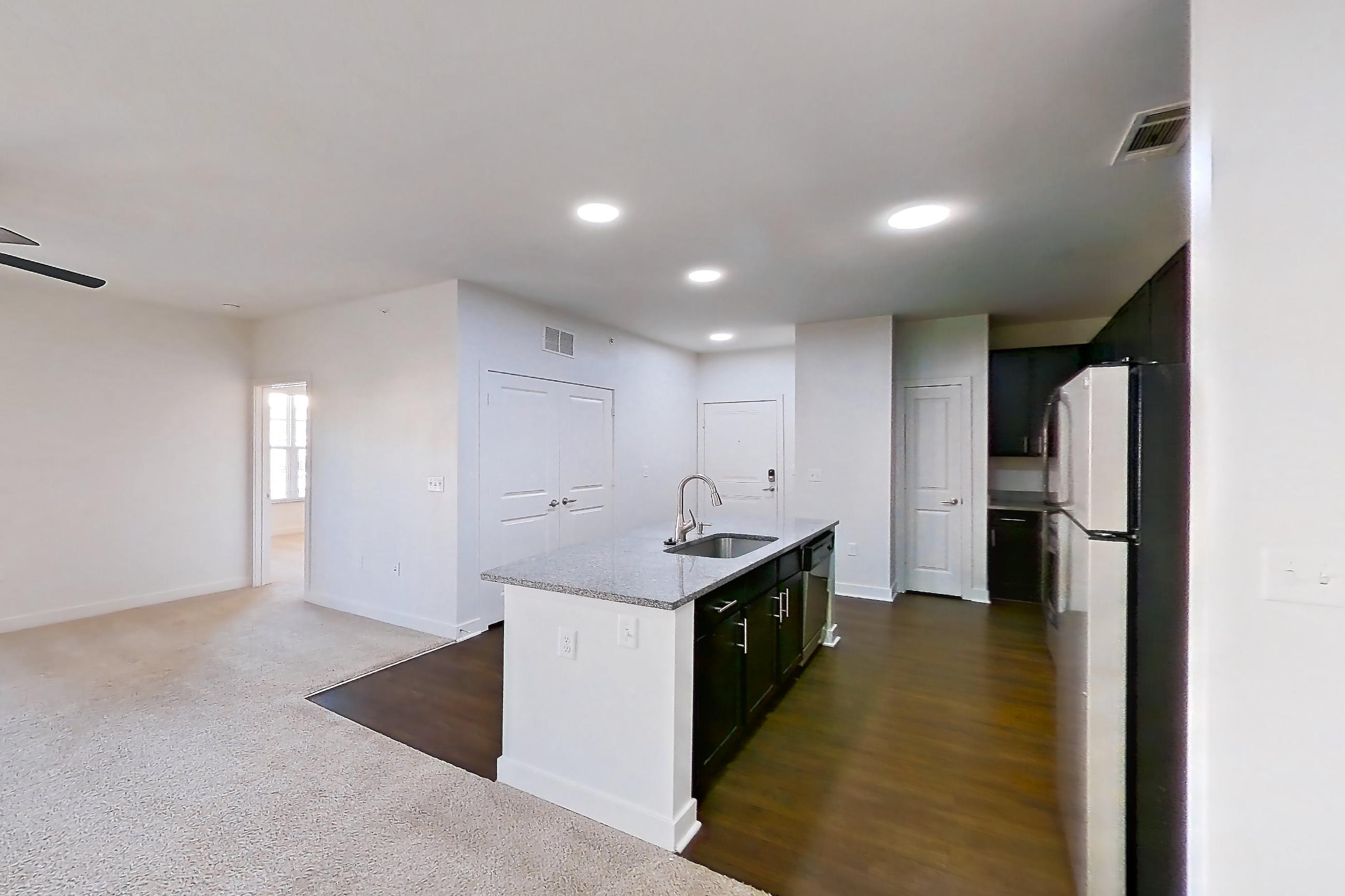 Dining room with dark carpet, dishwasher, kitchen island, light stone countertops, refrigerator, stainless steel appliances, and white appliances, Apartment 302 at Realm at Patterson Place