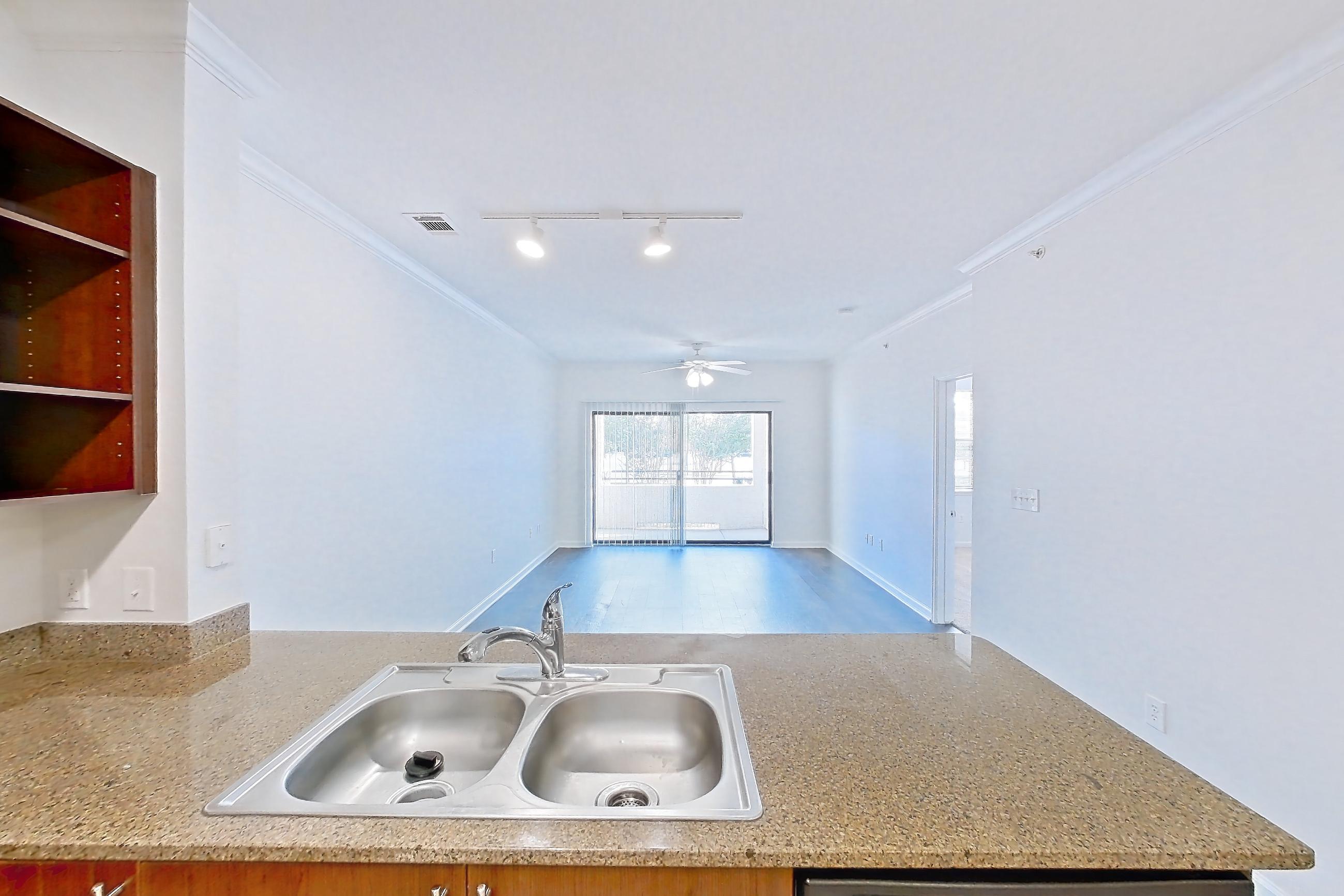 Kitchen with black appliances, dishwasher, electric range, light stone countertops, light tile flooring, microwave, oven/range, and stainless steel appliances, Apartment 1023 at The Cortona