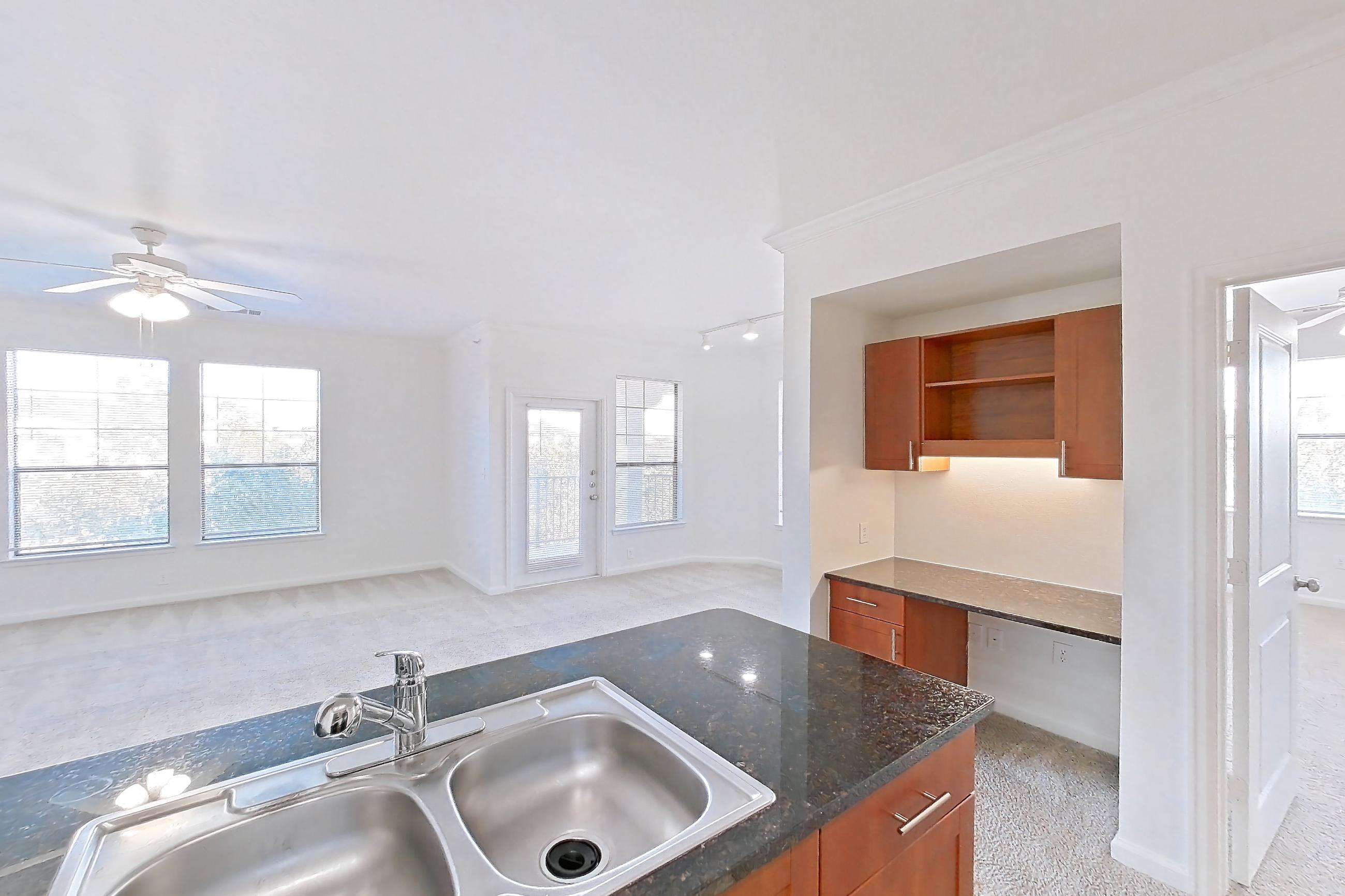 Kitchen with black appliances, dark stone countertops, dishwasher, light carpet, light tile flooring, and refrigerator, Apartment 1031 at The Cortona