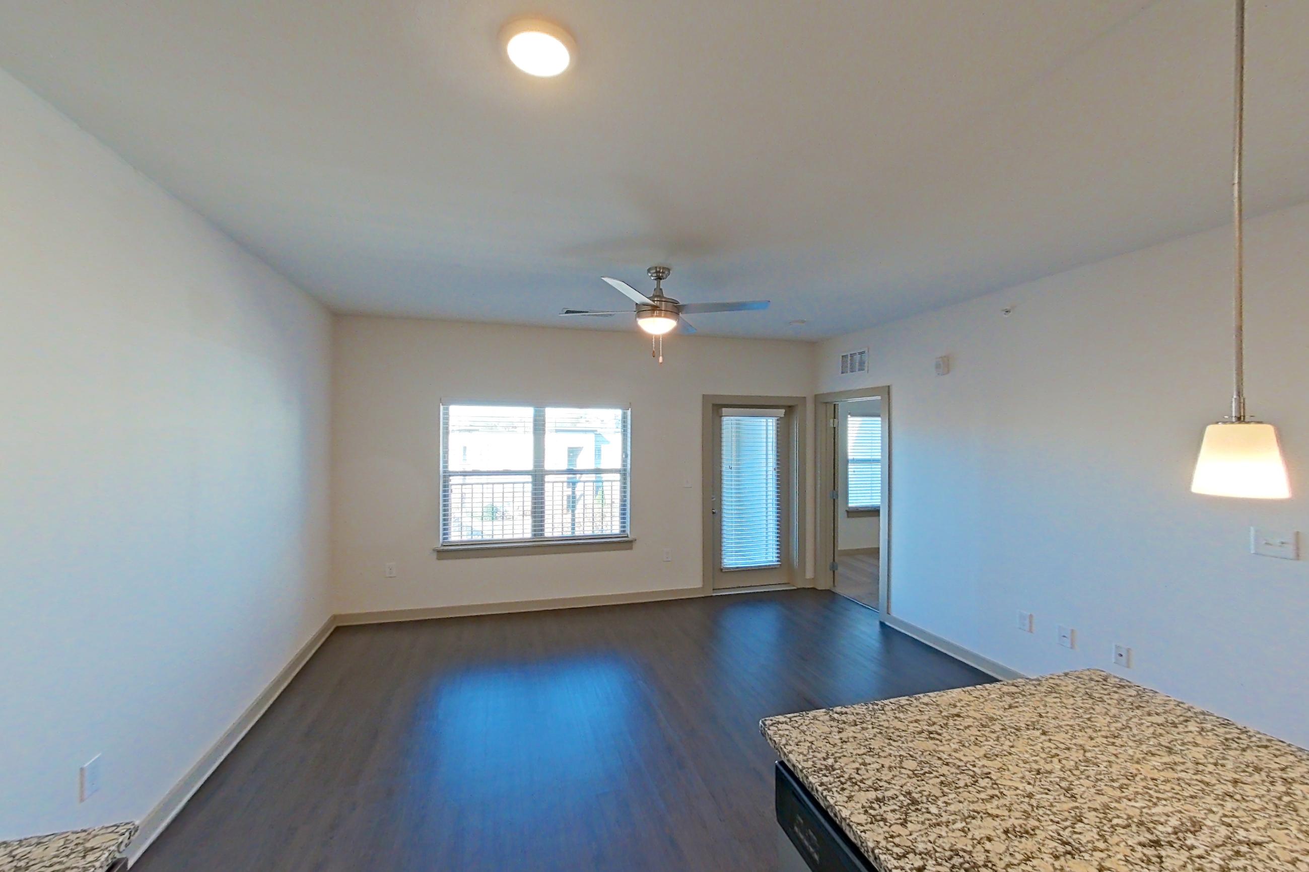 Kitchen with dark wood-finish flooring, dishwasher, electric range, light stone countertops, microwave, oven/range, refrigerator, stainless steel appliances, and water & ice dispenser, Apartment 1-506 at Aventine Northshore