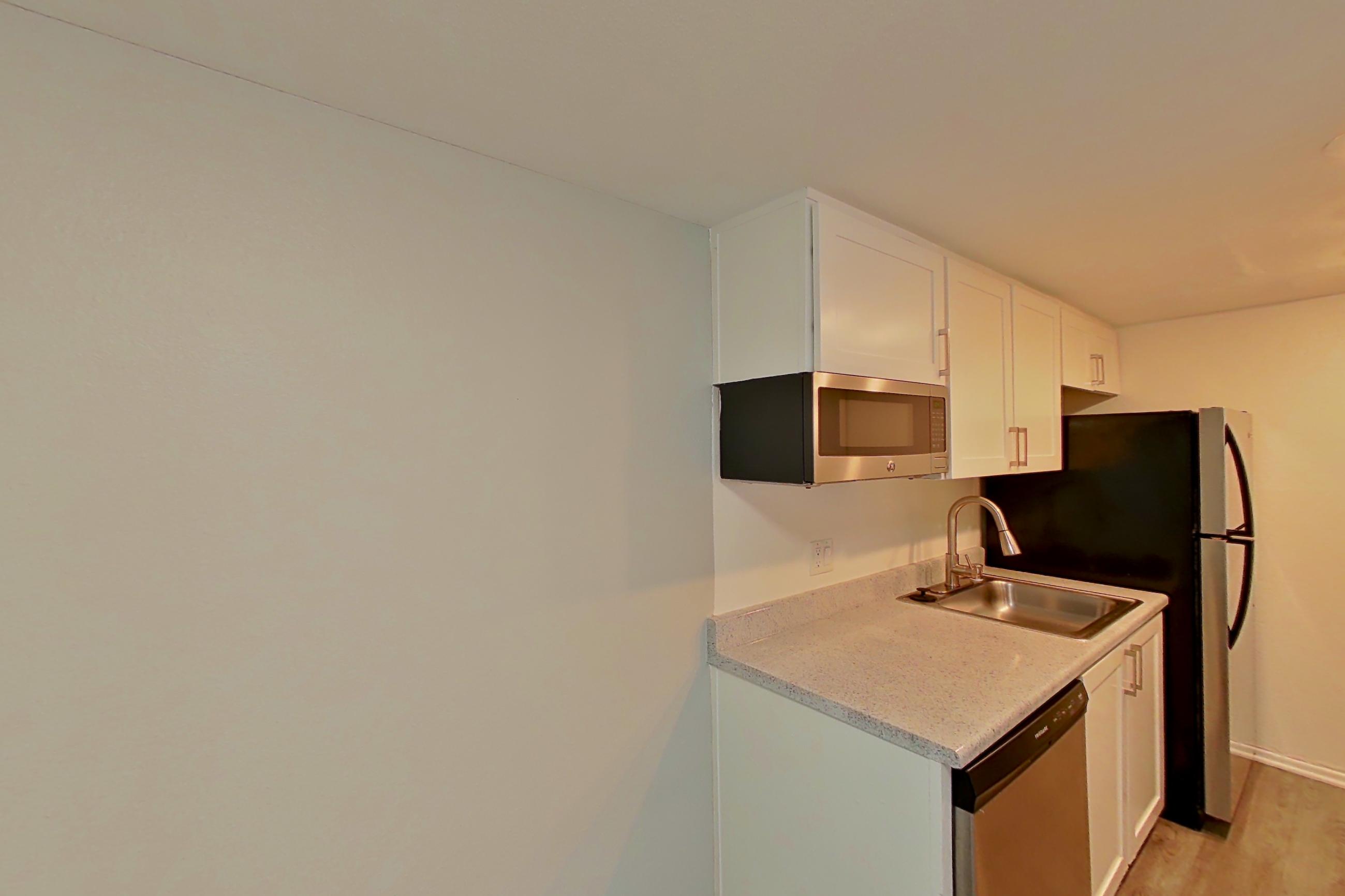 Dining area with dishwasher, electric range, light countertops, light stone countertops, light wood-finish flooring, oven/range, and stainless steel appliances, Apartment 06 at Avana Rancho Cucamonga