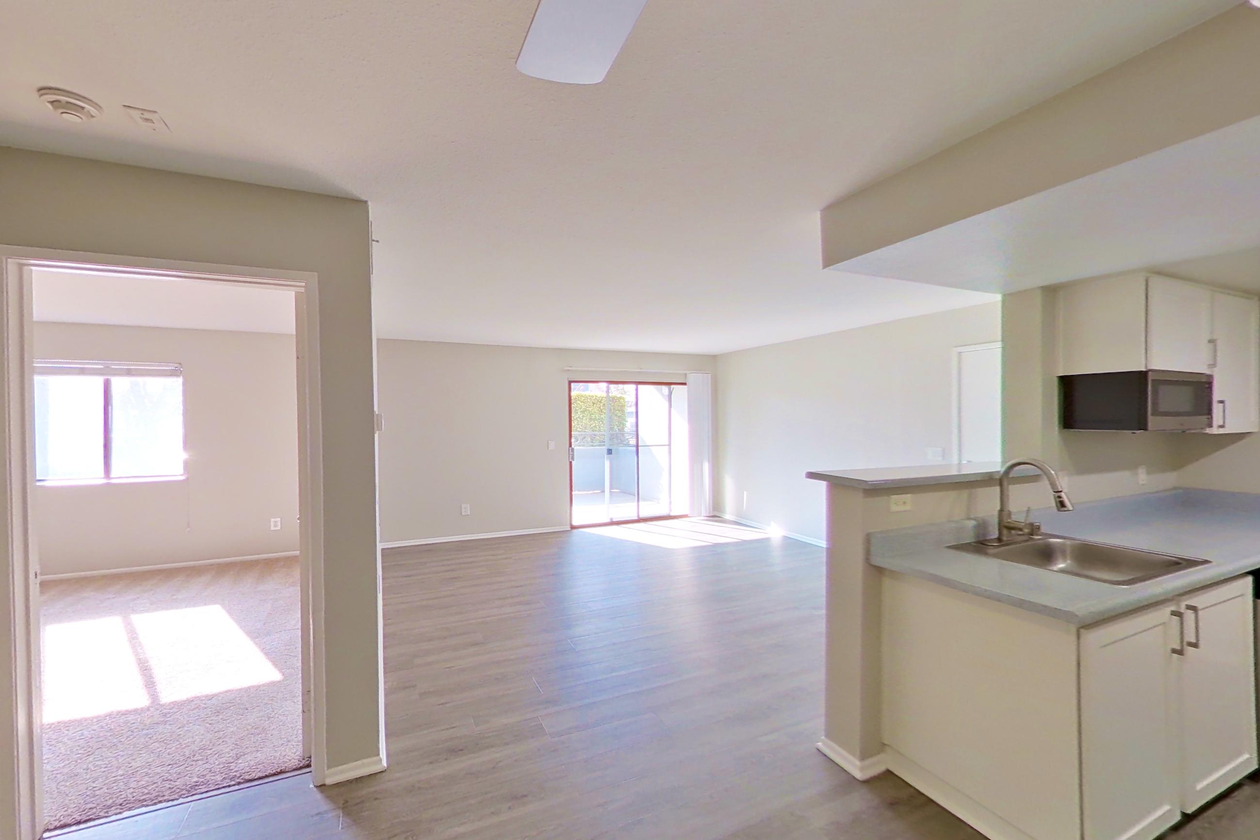 Dining area with dark wood-finish flooring, dishwasher, light countertops, light wood-finish flooring, and stainless steel appliances, Apartment 02 at Avana Rancho Cucamonga