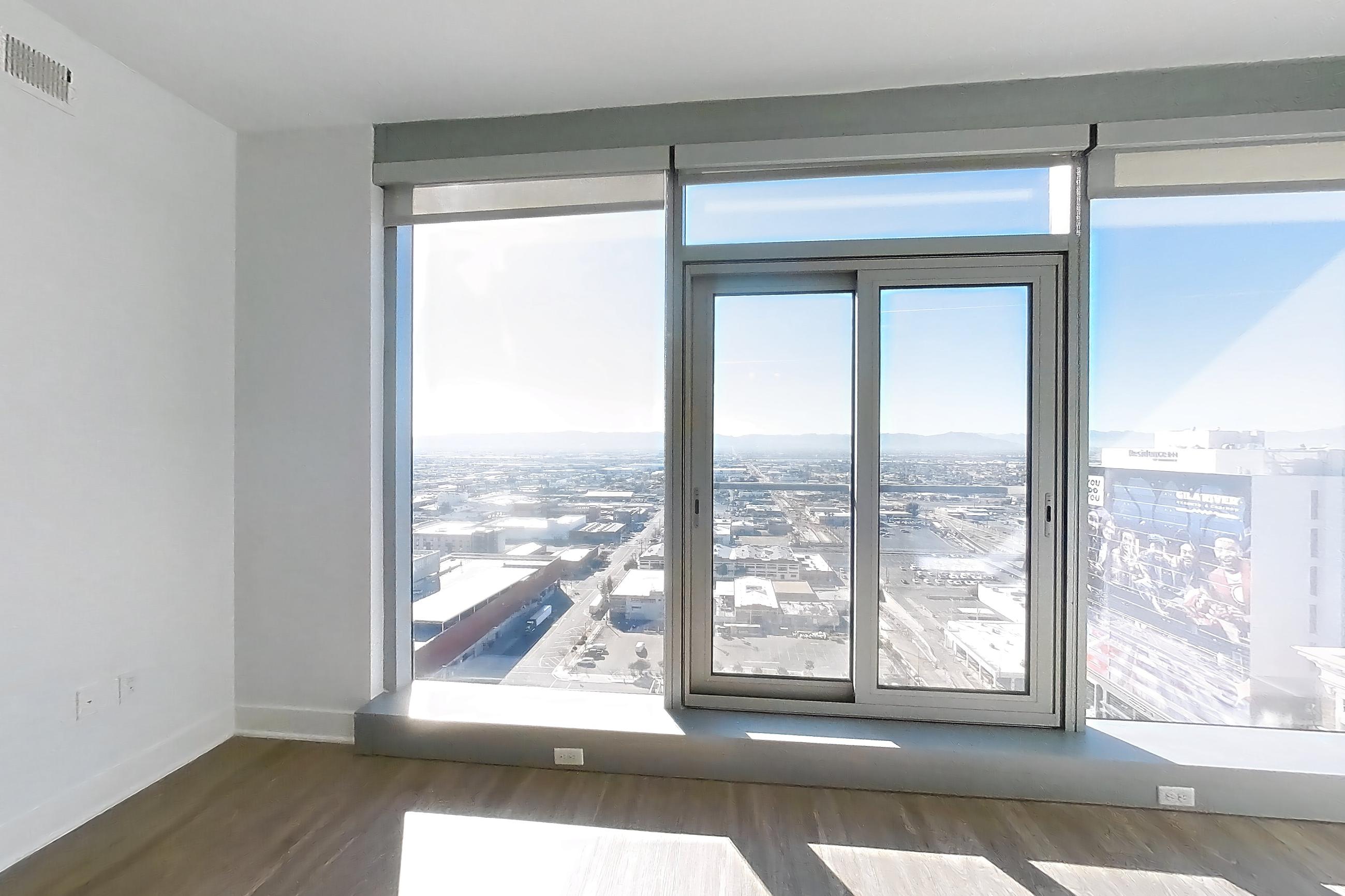 Living room with city view and dark wood-finish flooring, Apartment 2215 at Cityscape Residences