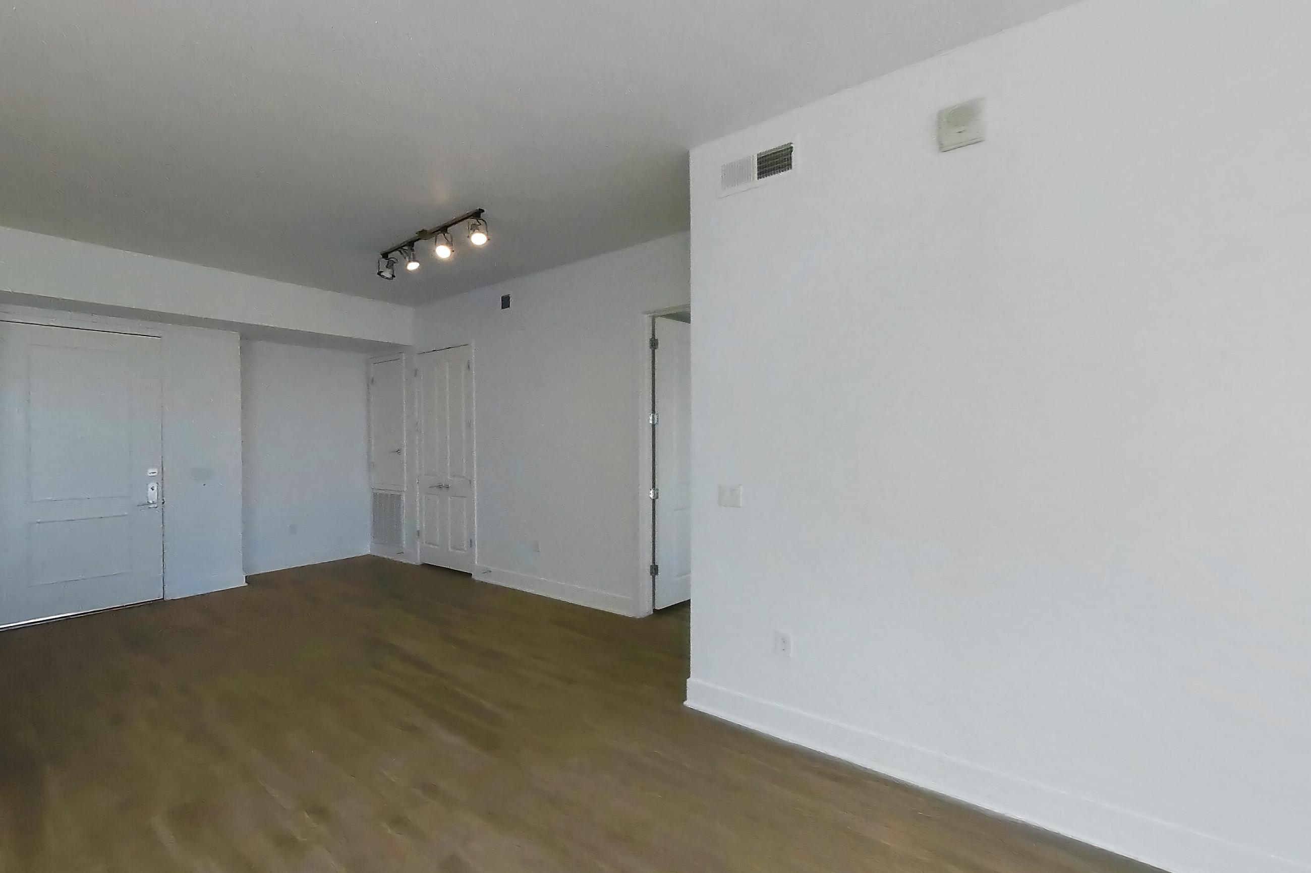 Living room with city view and dark wood-finish flooring, Apartment 2215 at Cityscape Residences