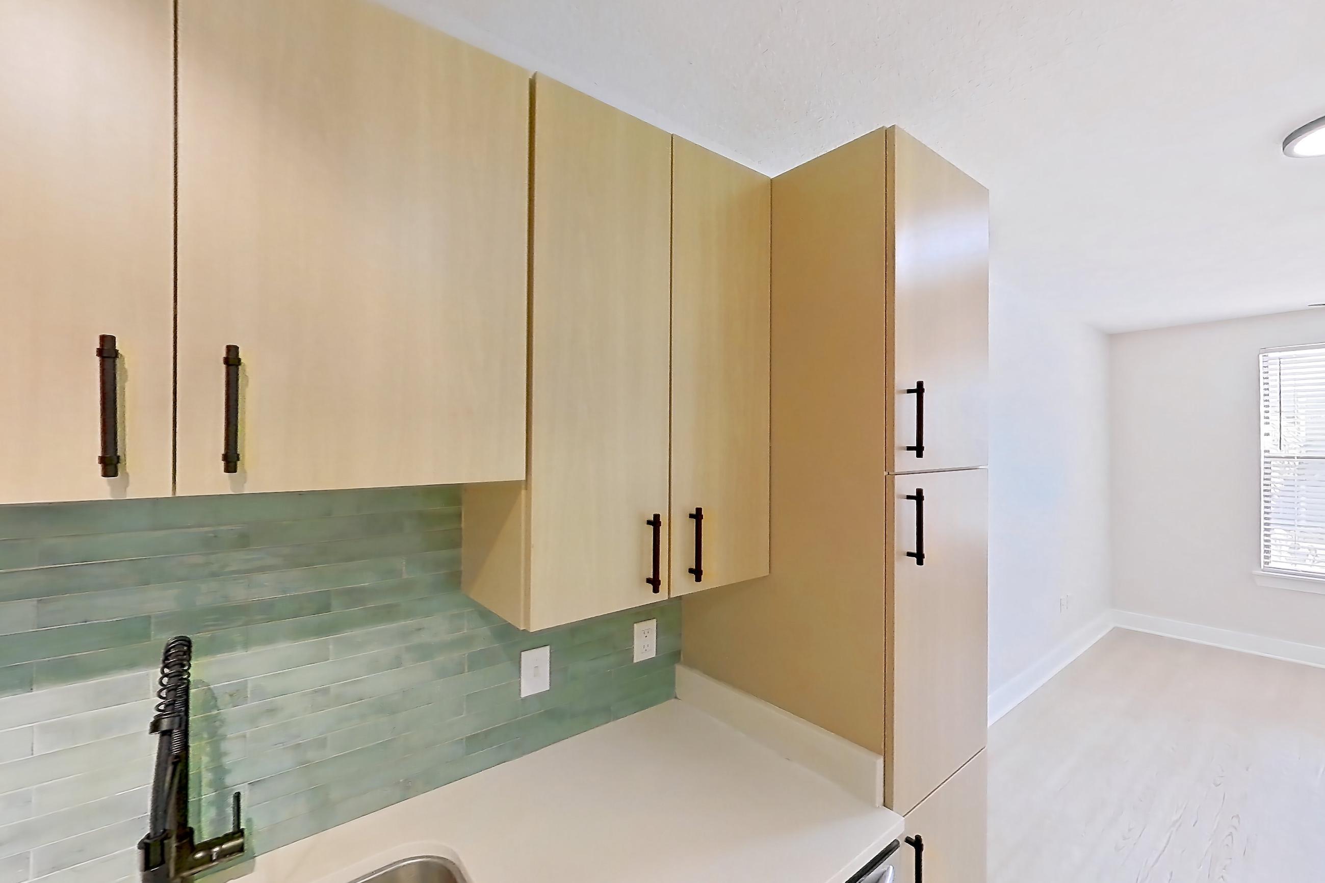 Kitchen with electric range, light countertops, light wood-finish flooring, microwave, oven/range, refrigerator, and stainless steel appliances, Apartment 3233 at NoHo Flats