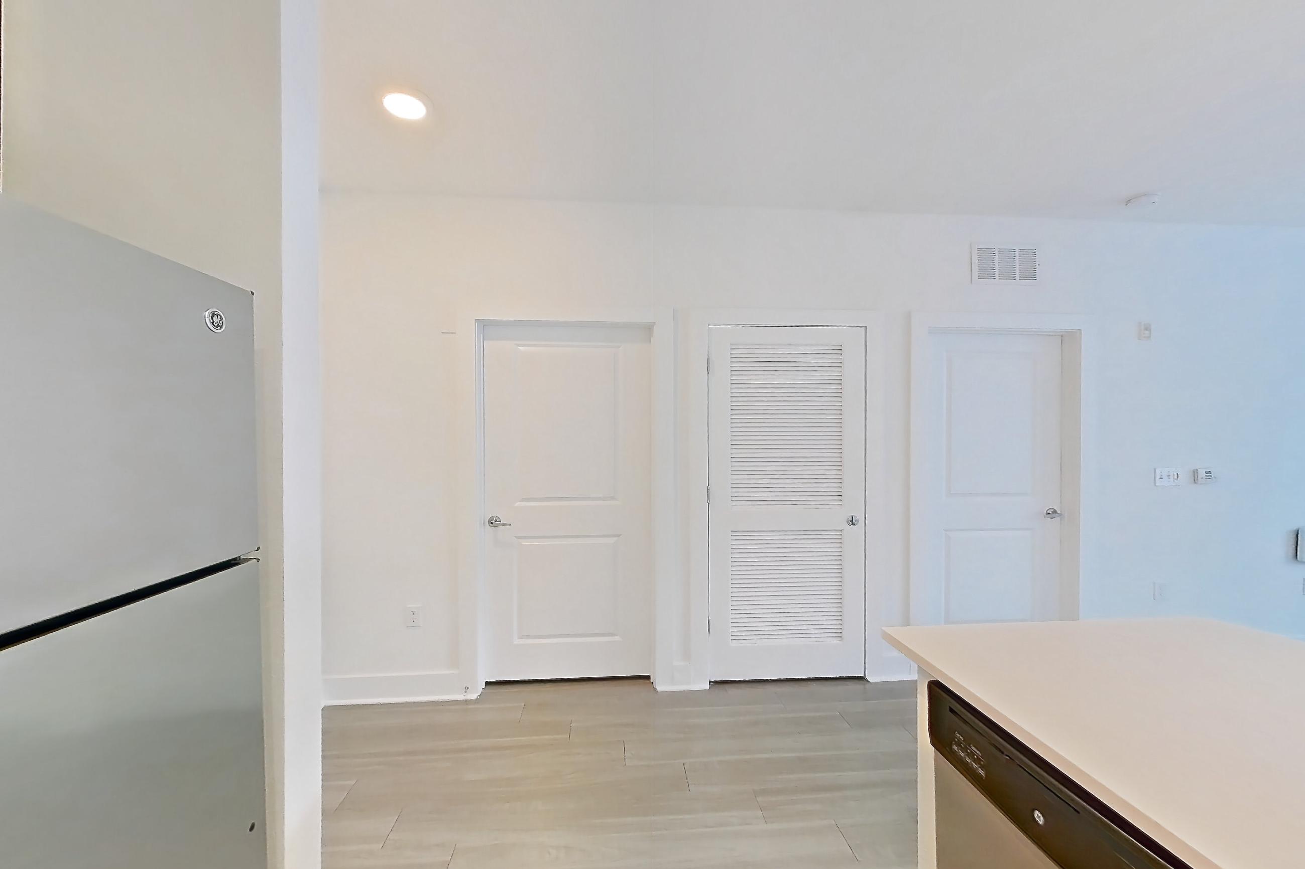 Kitchen with dishwasher, electric range, light countertops, light wood-finish flooring, oven/range, refrigerator, and stainless steel appliances, Apartment 4108 at NoHo Flats