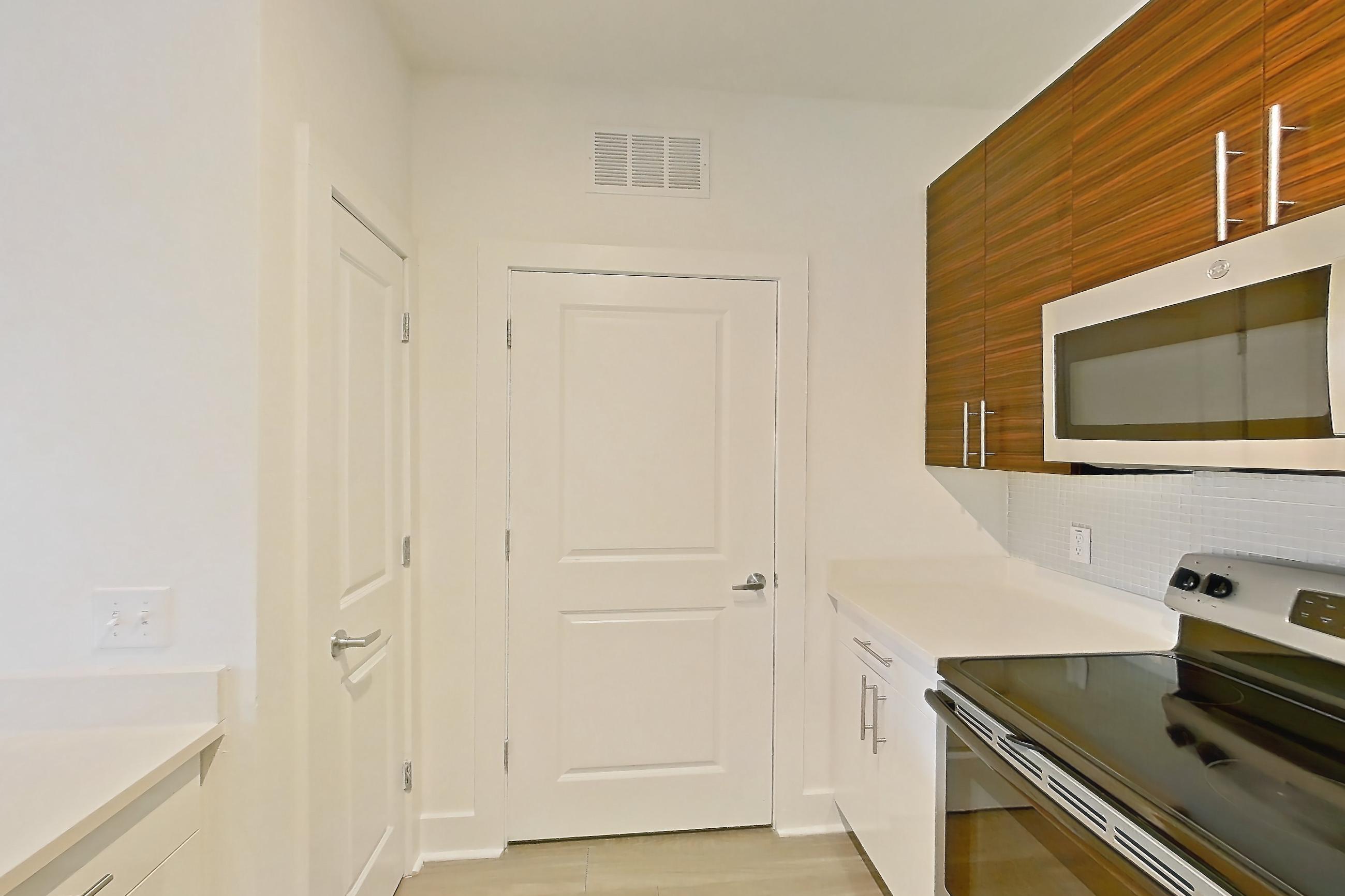 Kitchen with dishwasher, electric range, light countertops, light wood-finish flooring, oven/range, refrigerator, and stainless steel appliances, Apartment 4108 at NoHo Flats