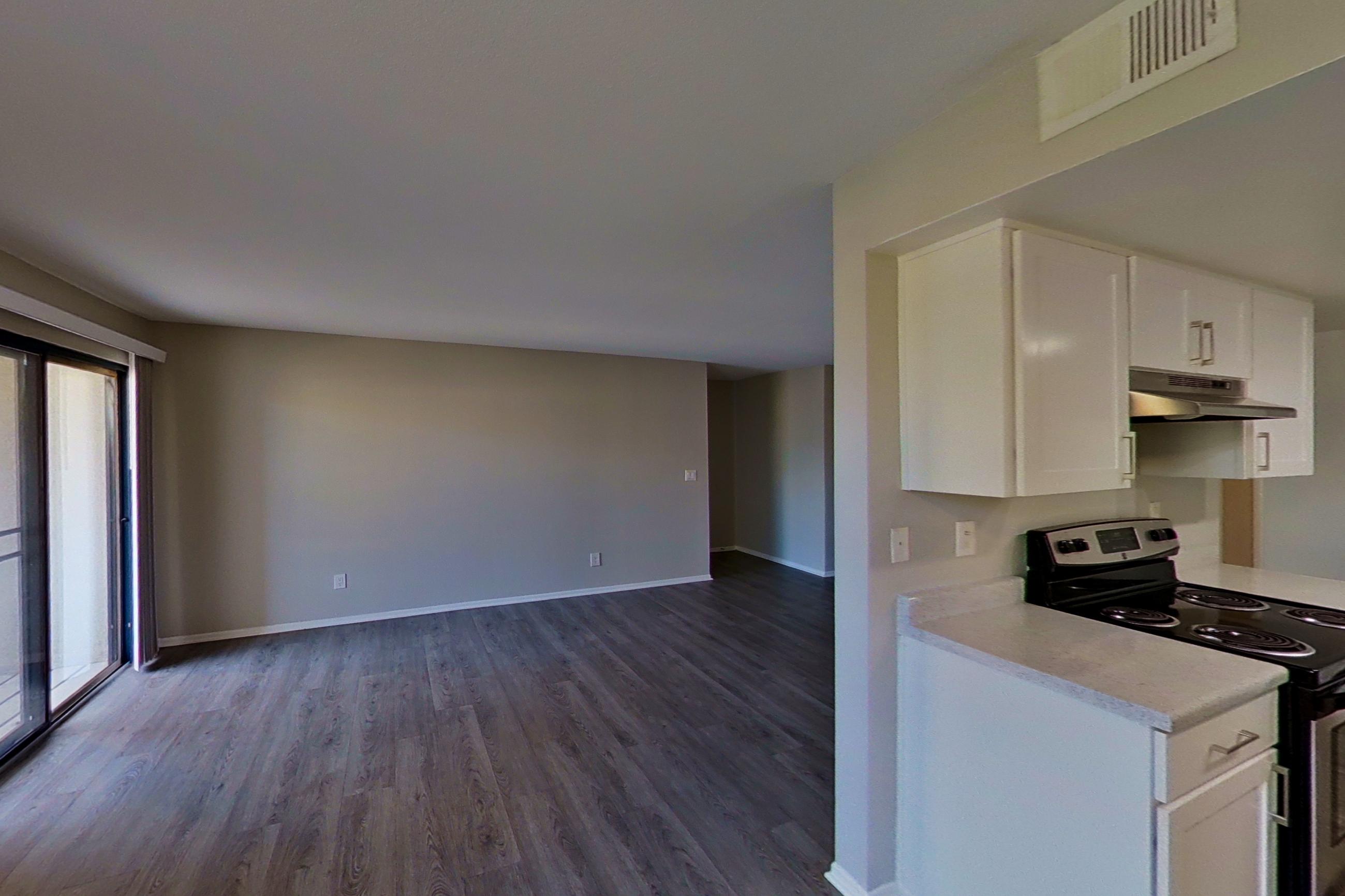 Dining area with dark wood-finish flooring, electric range, light countertops, oven/range, and stainless steel appliances, Apartment 03 at Avana Rancho Cucamonga