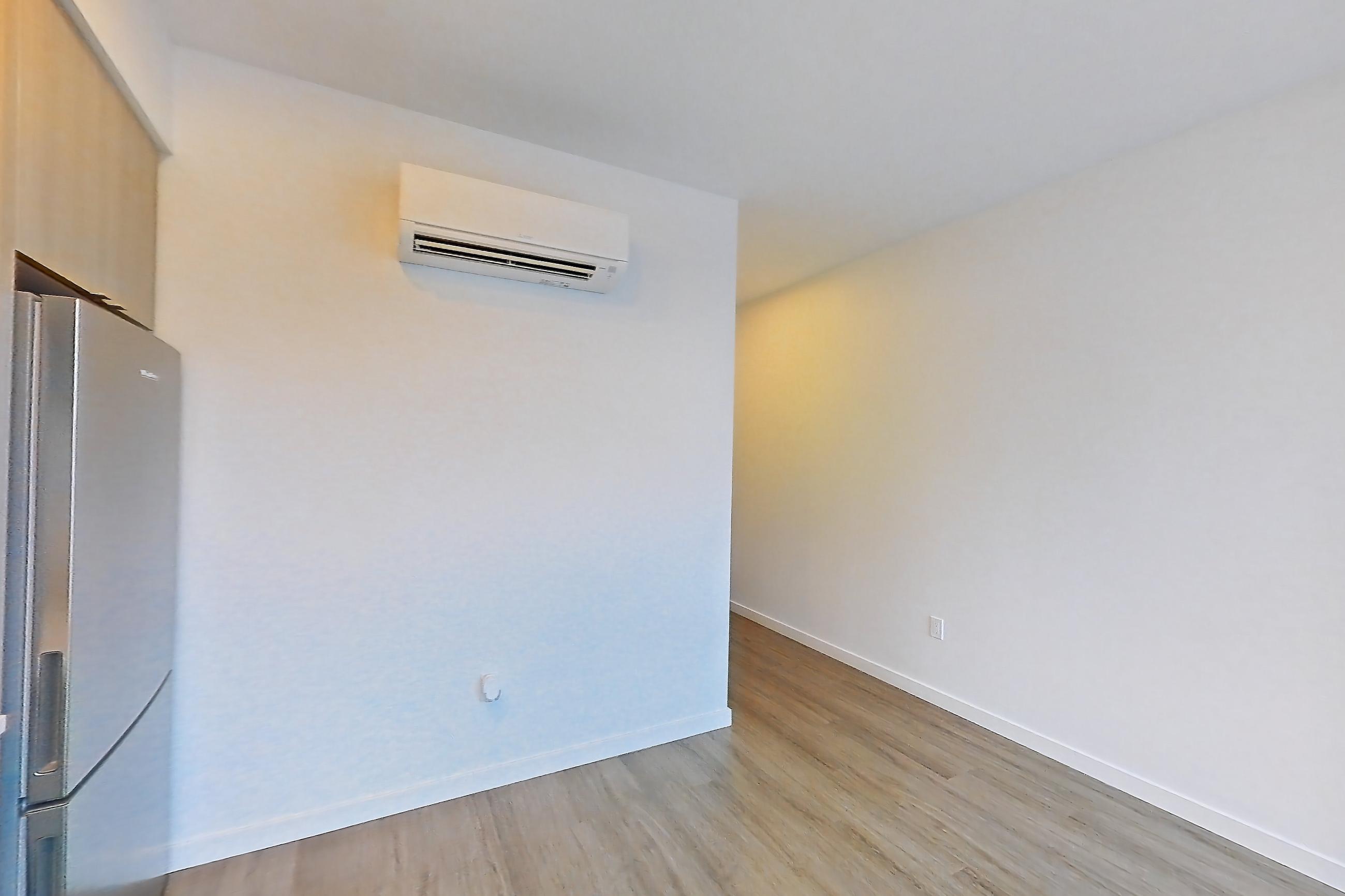 Kitchen with dishwasher, electric range, light countertops, light stone countertops, light wood-finish flooring, microwave, mini-split AC, oven/range, refrigerator, and stainless steel appliances, Apartment 733 at The Cline
