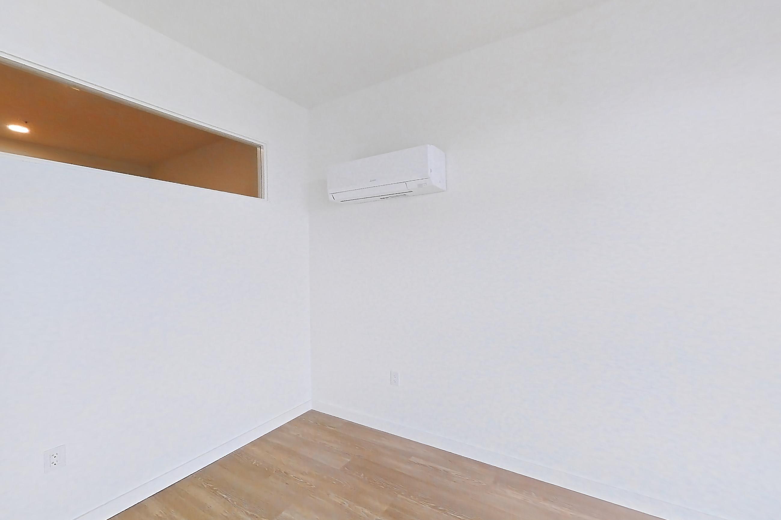 Living room with light wood-finish flooring and mini-split AC, Apartment 804 at The Victor