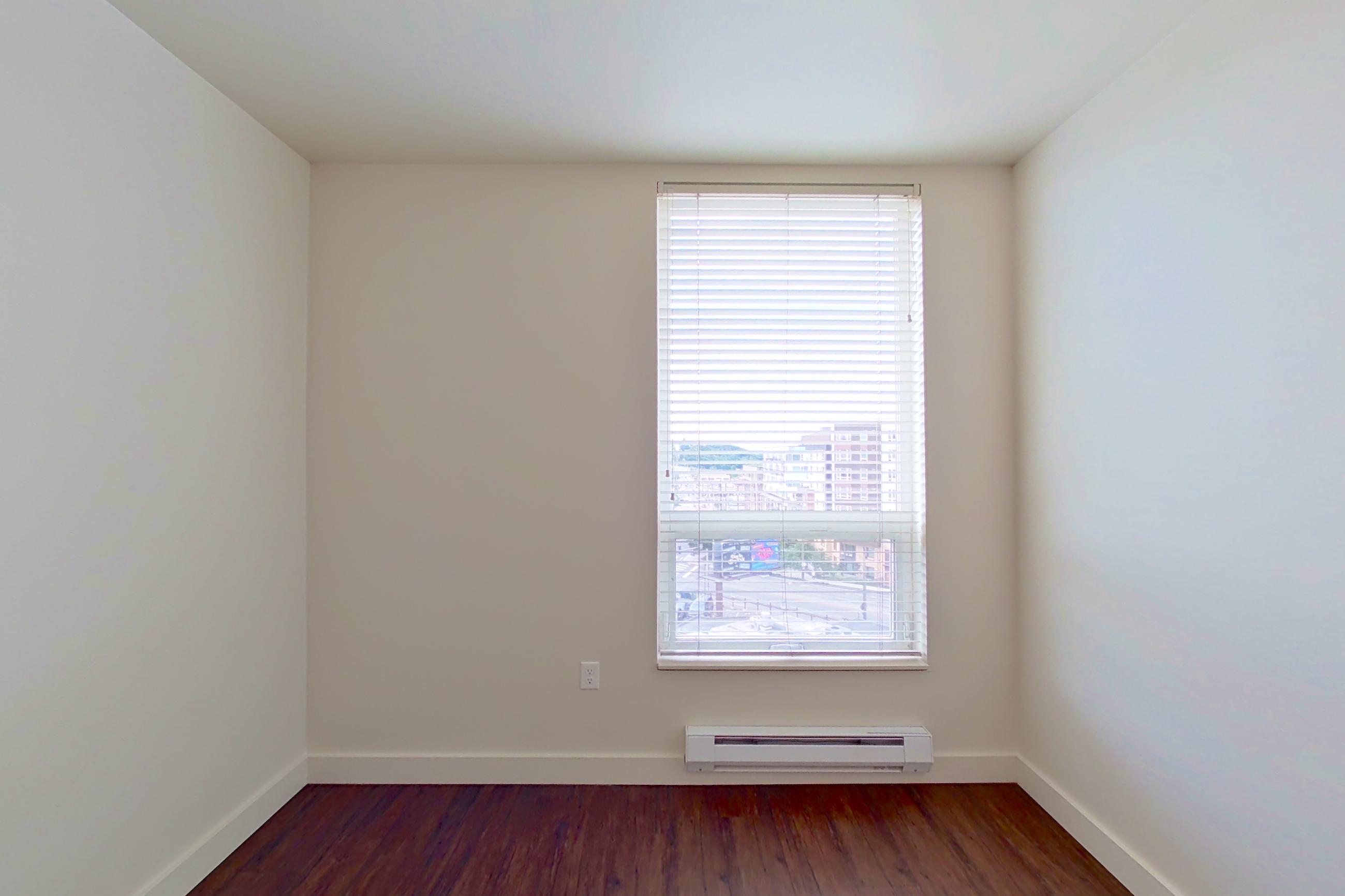 Bedroom with dark wood-finish flooring, Apartment 618 at Anthem on 12th